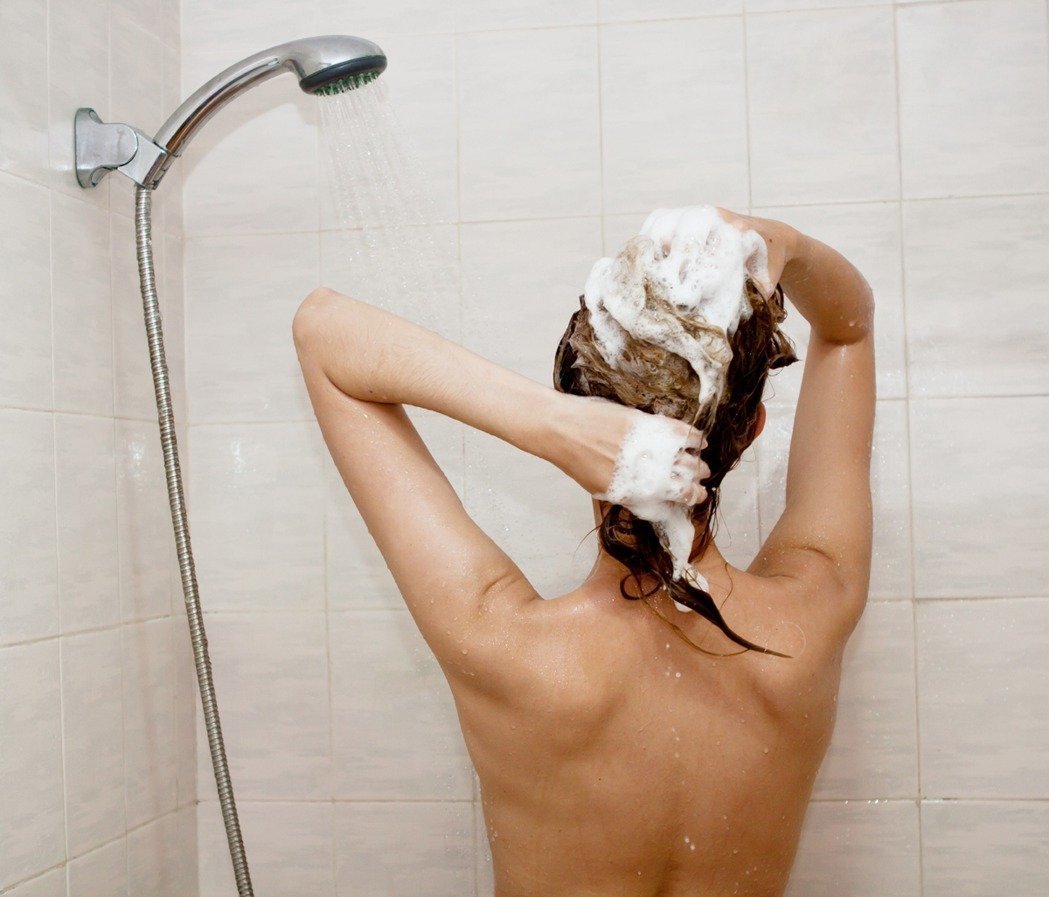 Грудастая девка моется в душе перед камерой