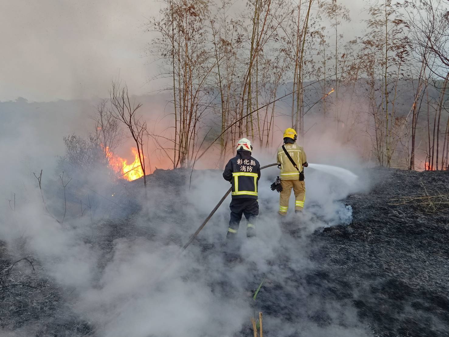 彰化市东区八卦山区近日火烧山，消防人员在火场中灌救。图／消防局提供