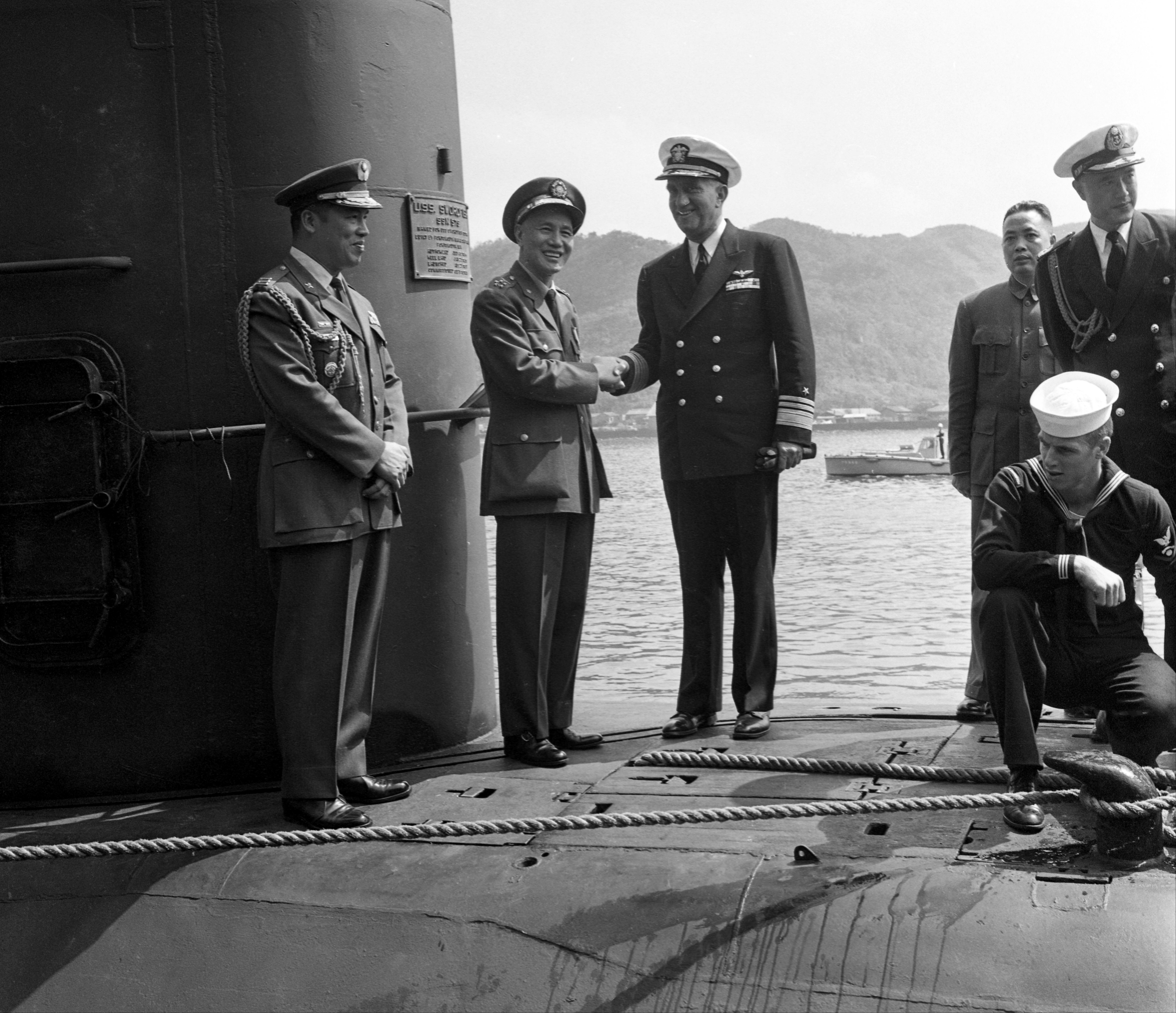 1960年3月8日，美国海军核子潜艇「剑鱼」号抵达台北基隆港第18号码头，图为时任总统蒋中正（左二）与舰长赖狄克（左三）握手致意。图／联合报系资料照片