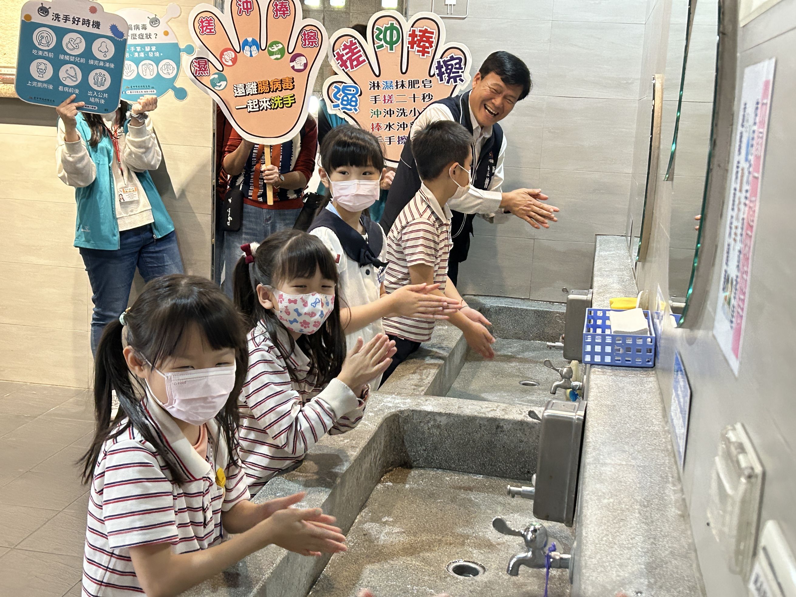 卫生局长曾梓展（后）今教学童正确洗手五步骤「湿、搓、冲、捧、擦」。记者赵容萱／摄影
