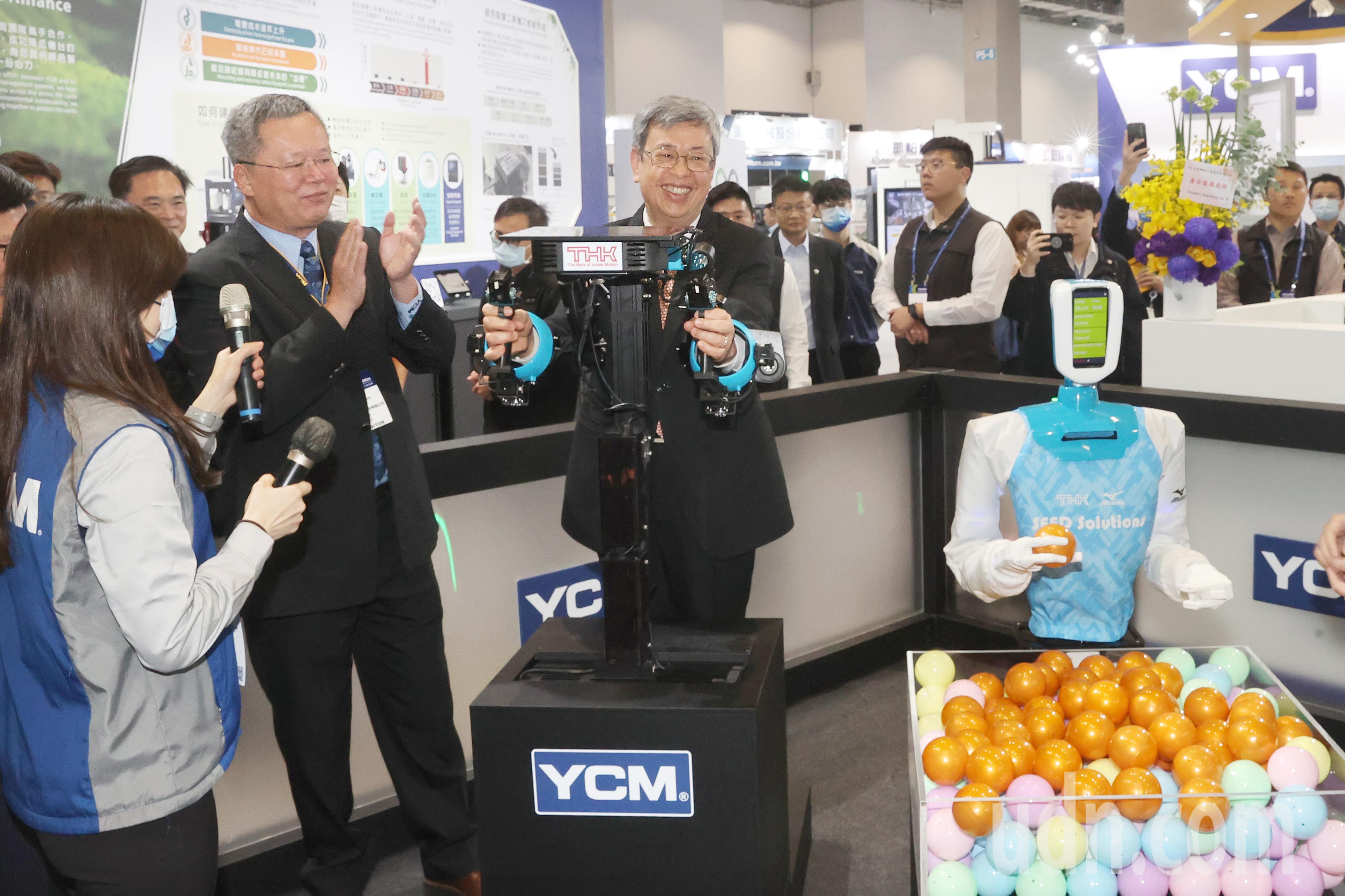 行政院长陈建仁（中）上午出席台湾国际工具机展，陈建仁操作 YCM X THK 联合生产的「SEED」机器人成功抓起一颗球，一旁的永进机械董事长陈伯洋（左二）拍手鼓掌。记者苏健忠／摄影
