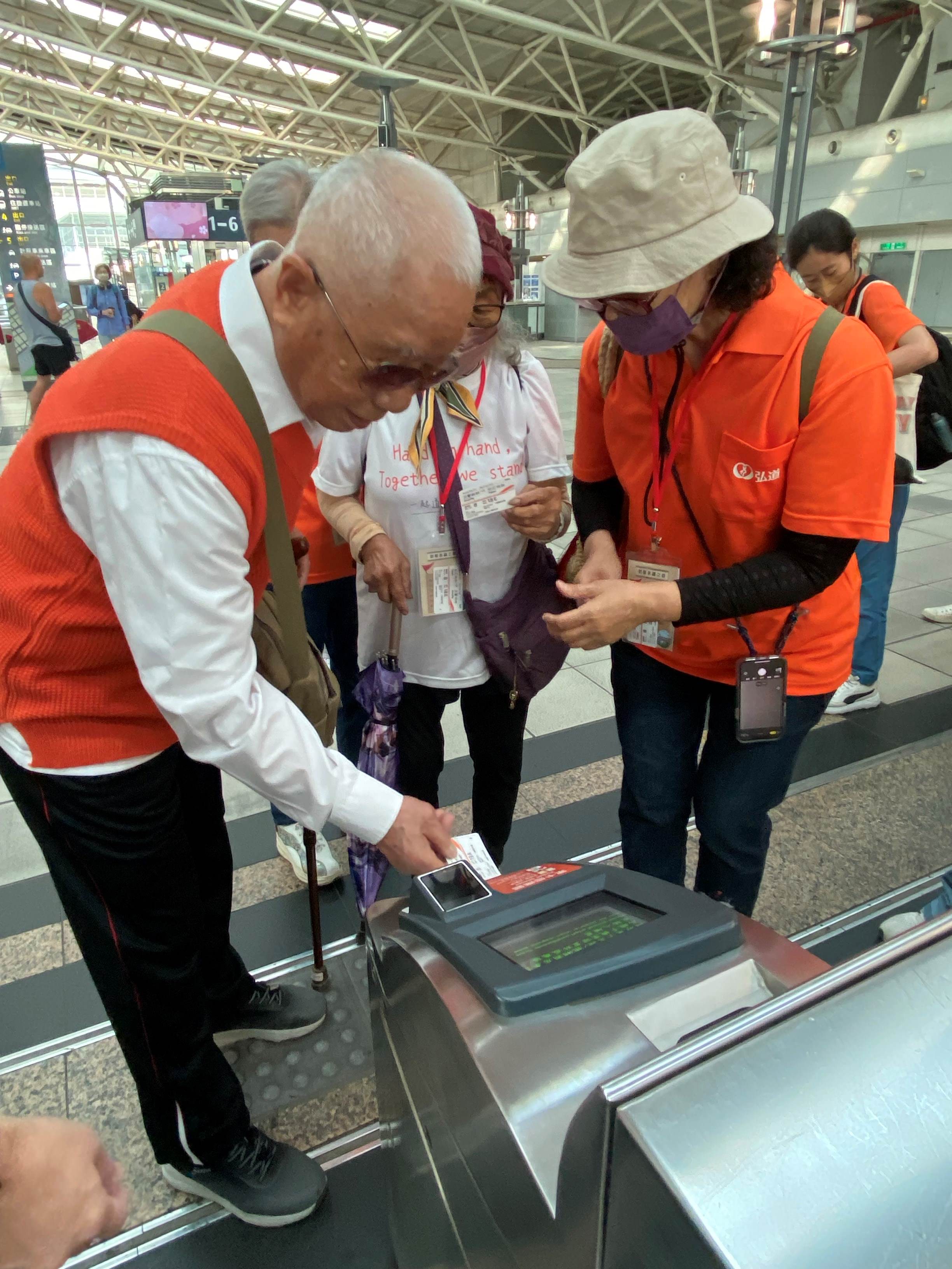 高铁左营站邀请97岁的丁爷爷与76岁的沈奶奶化身「高铁一日站务员」，帮忙同行长辈过票搭车。记者潘奕言／翻摄