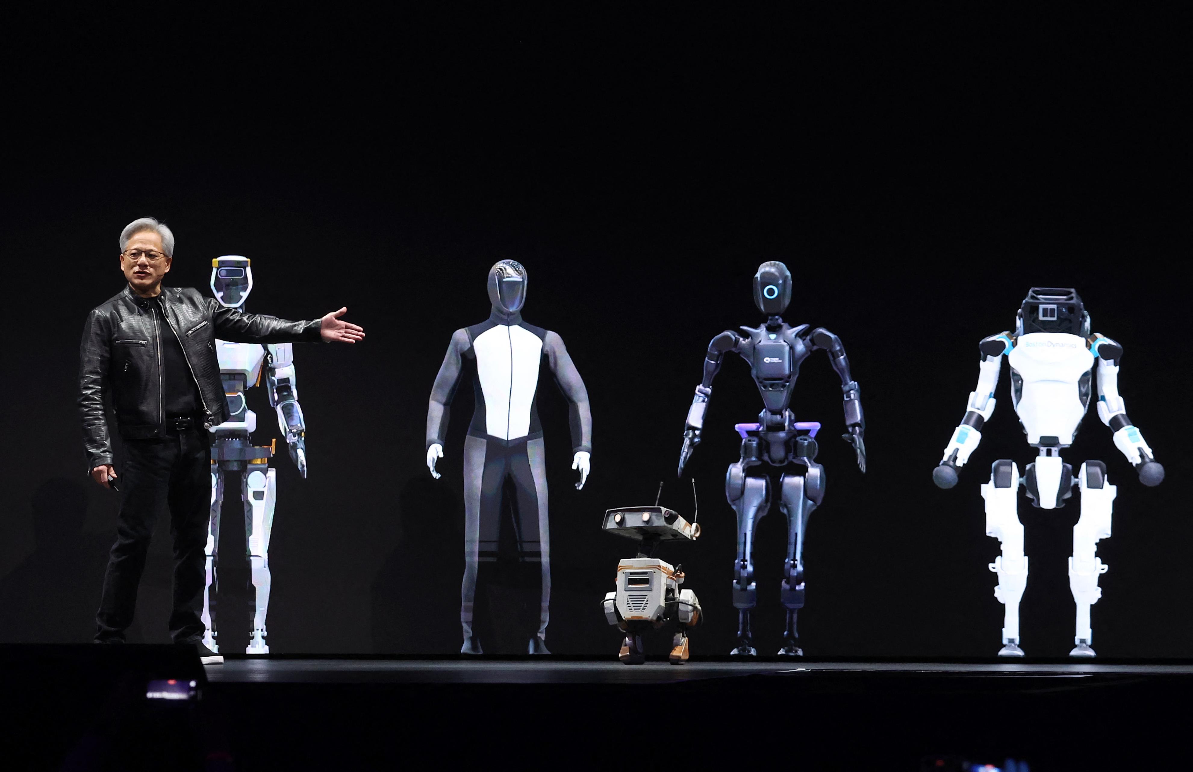 黄仁勋在2024年GTC AI大会上身旁的人形机器人引发关注。法新社