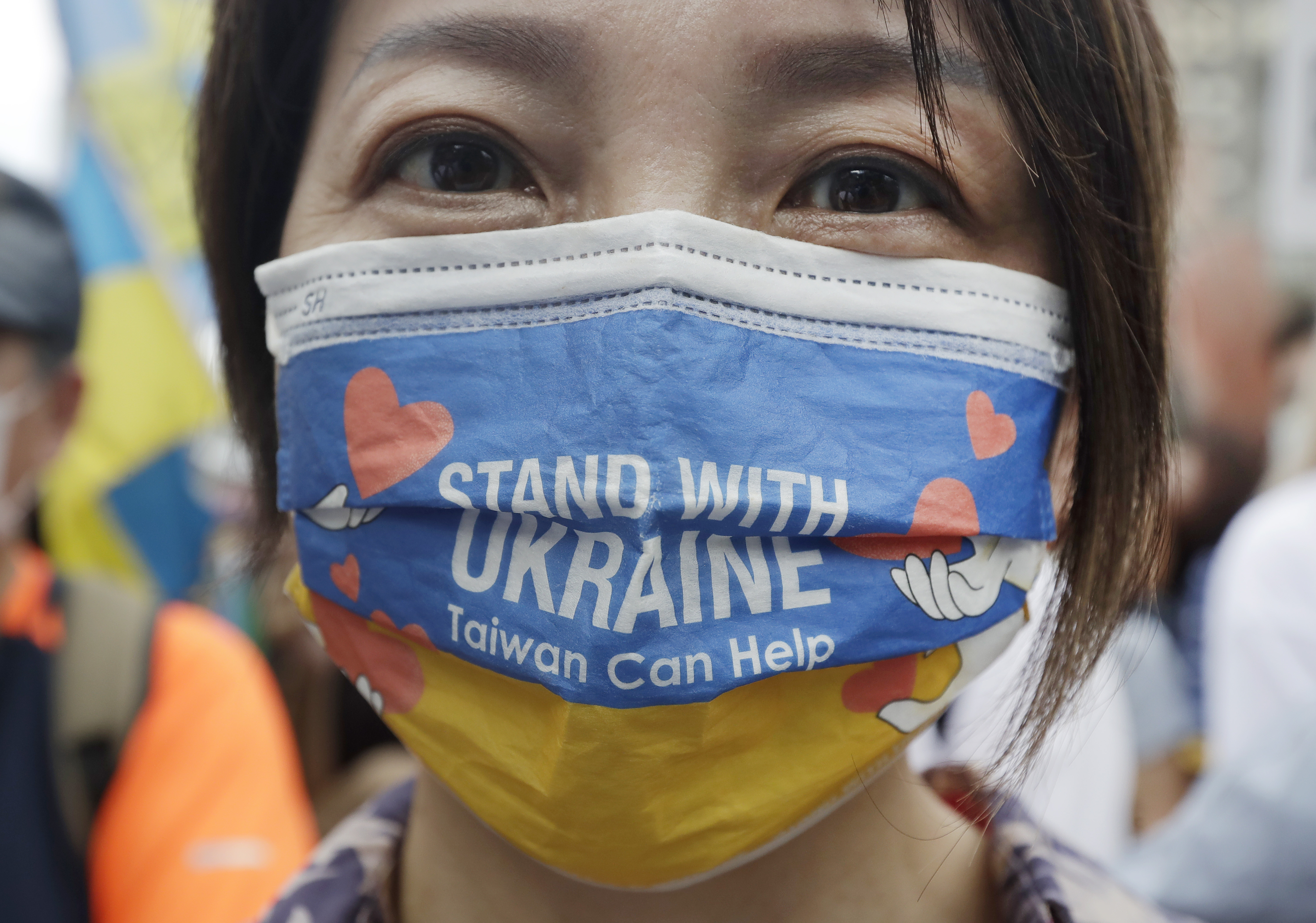 俄乌战争自2022年2月24日全面爆发至今已有2年，台湾始终秉持大力援助的态度，外交部即在第一时间就进行捐款，以协助乌克兰的难民安置。图为台湾街头民众戴著支持乌克兰的口罩。美联社