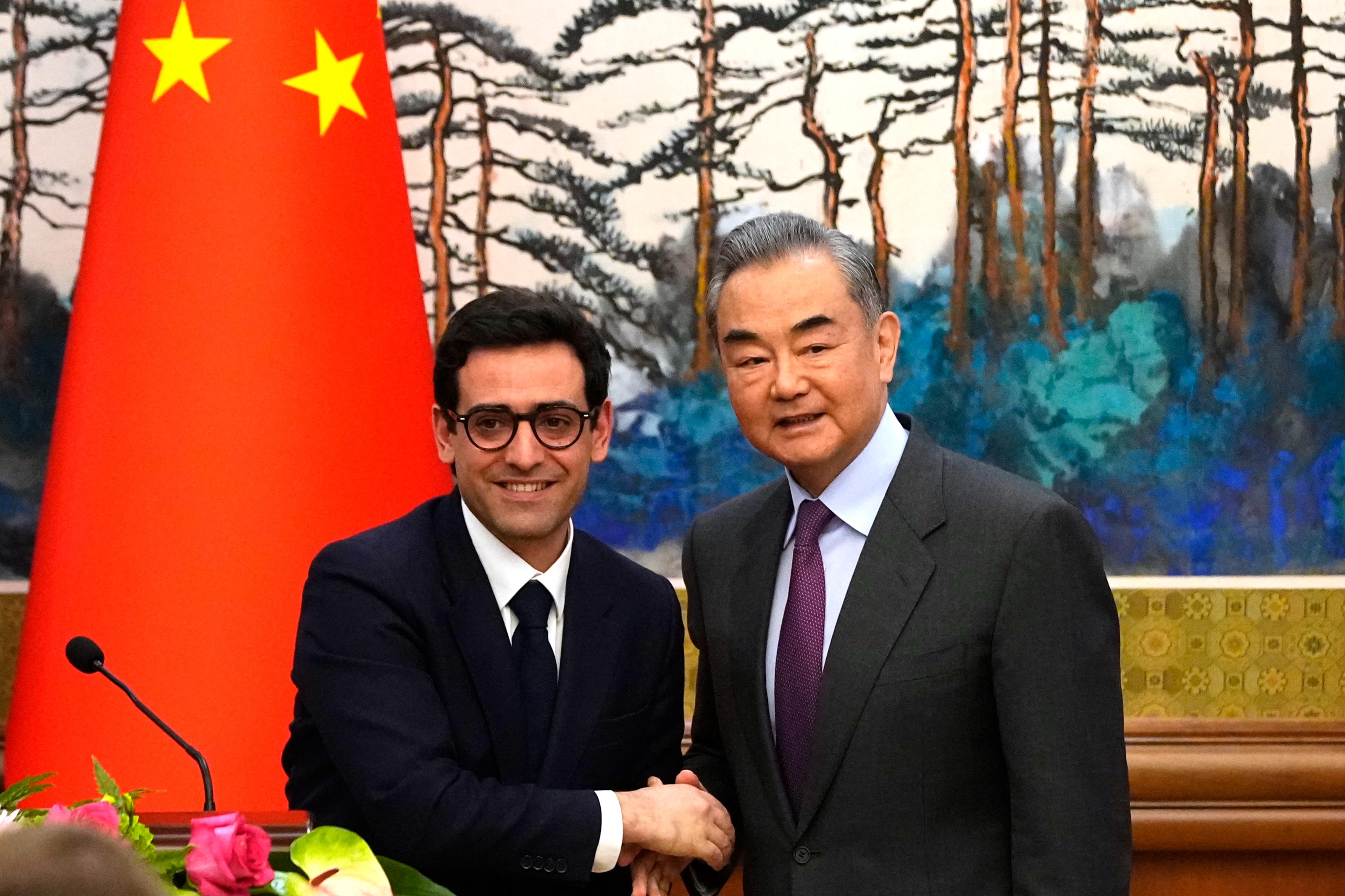 大陆外长王毅1日上午在北京会见到访的法国长塞儒内。（美联社）