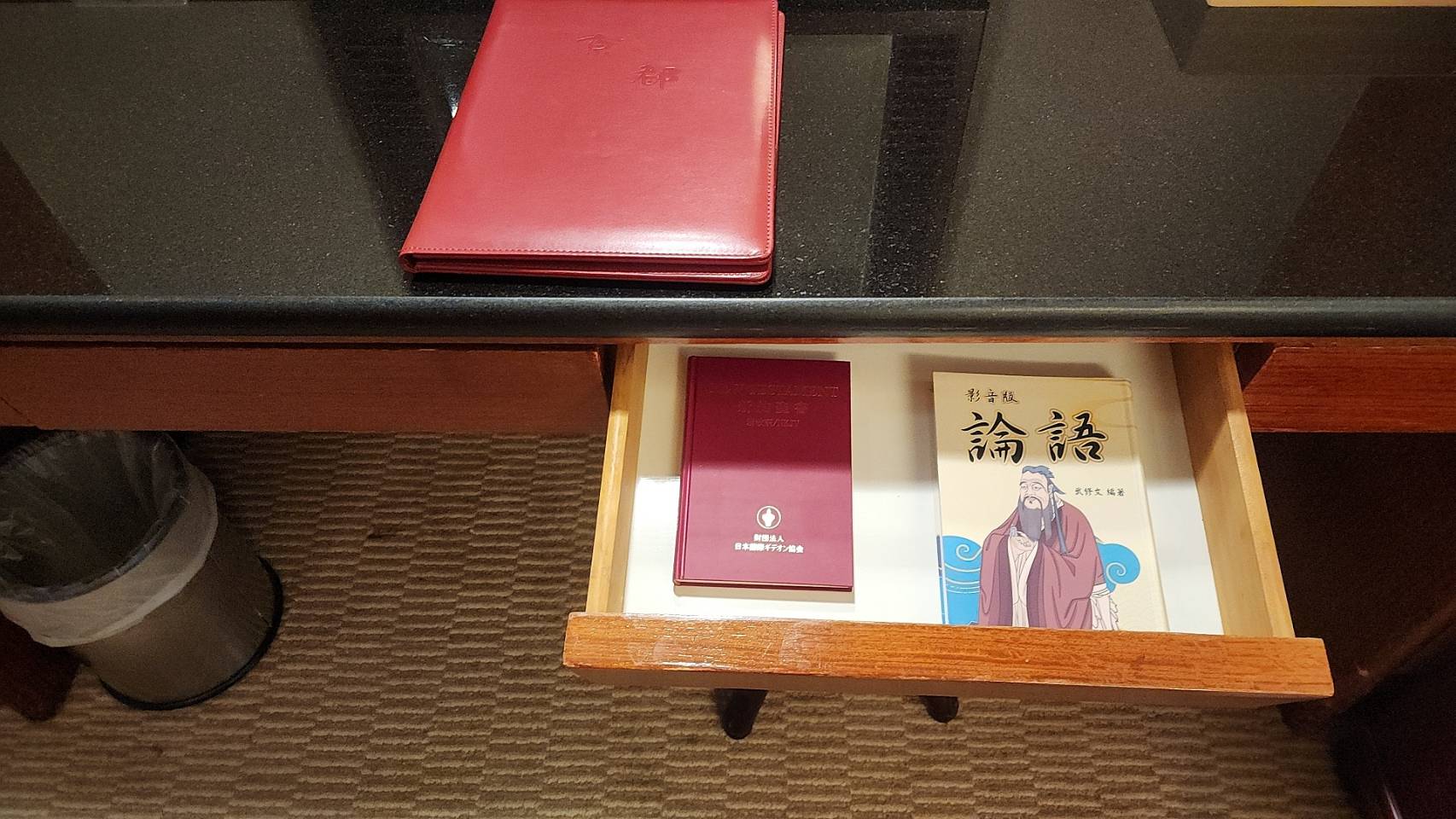 以日客为主的京都商务旅馆，饭店房间内的抽屉打开，除了常见的圣经外，还有特别印制的影音版《论语》。图／徐银树提供