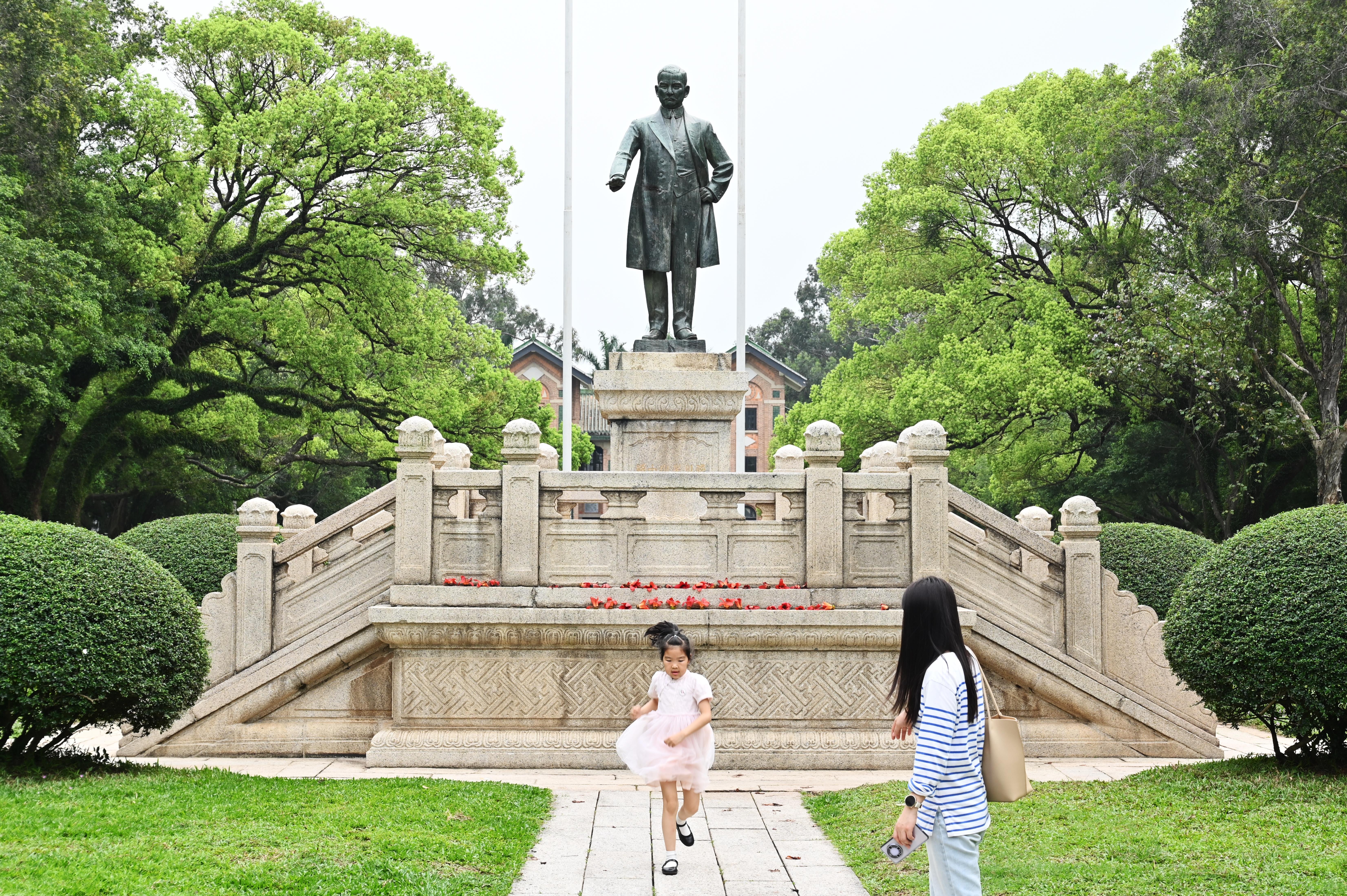 3月31日，广东省广州市，参观者从中山大学孙中山雕像前经过。（中新社）