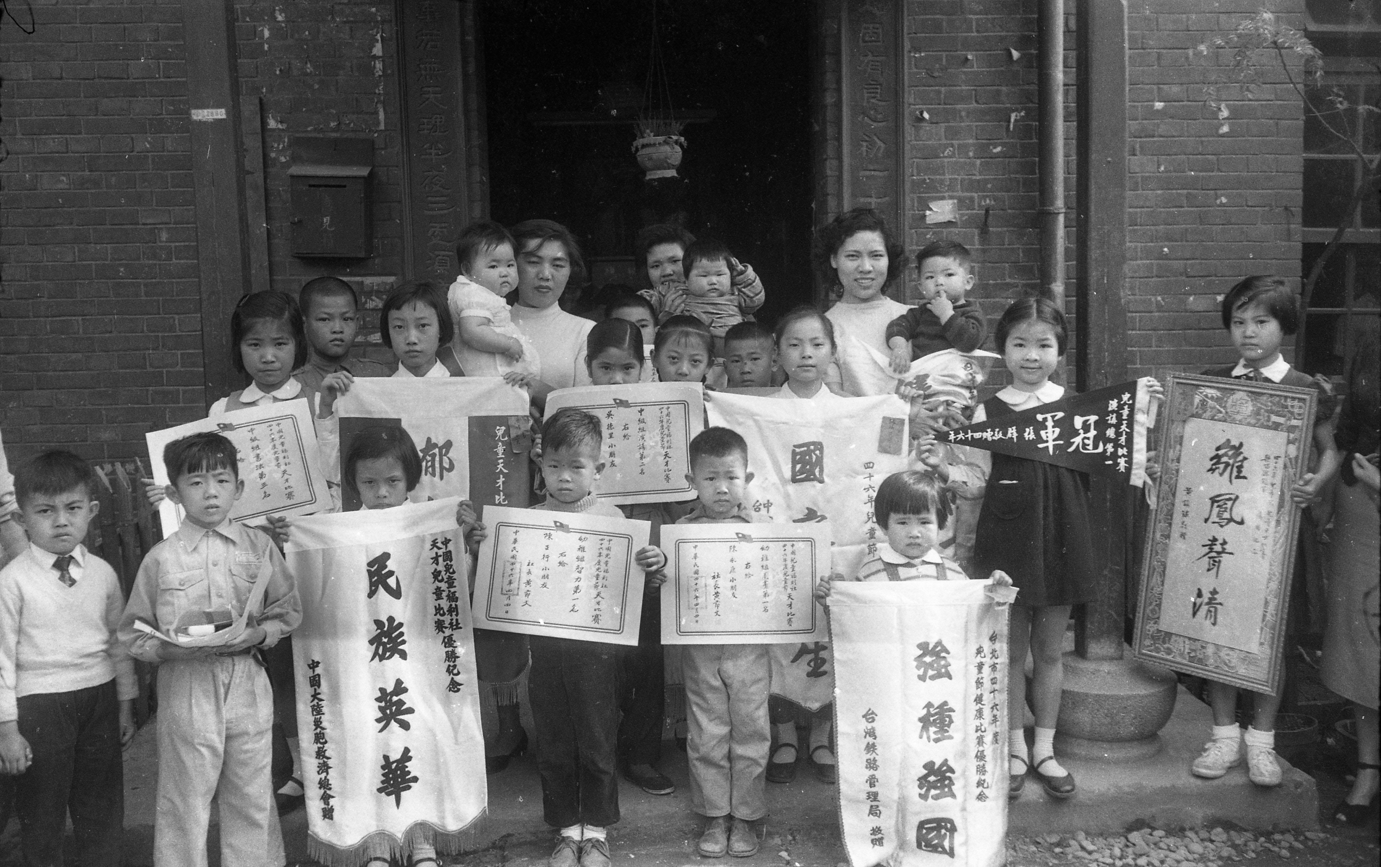 1957年4月6日，中国儿童福利社举办的儿童健康比赛及各科儿童天才比赛，当日下午颁奖，会中学童们拿著得奖锦旗合影。图／联合报系资料照片