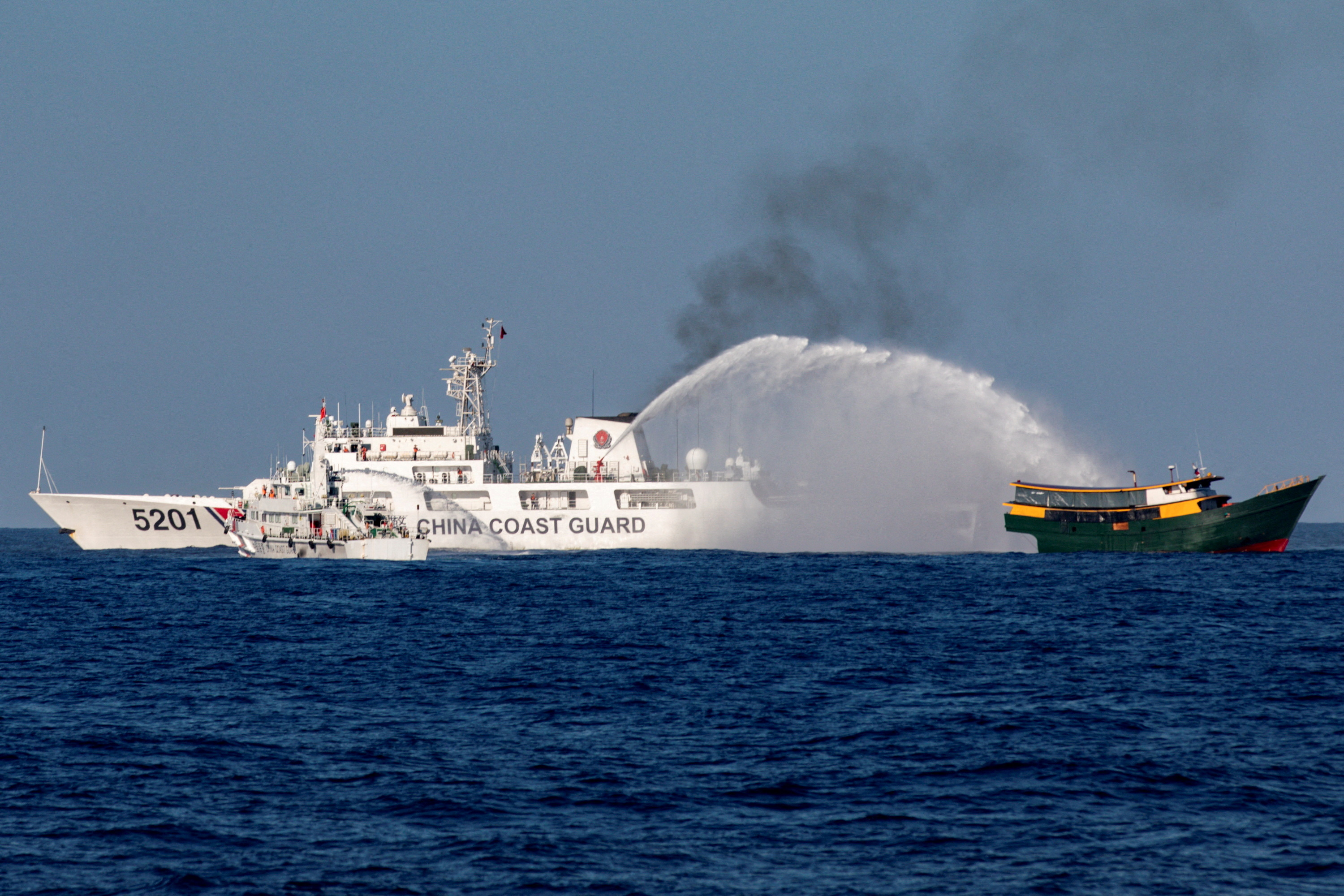 菲律宾海岸防卫队船只3月5日在南海执行运补任务时，遭中国海警（左）以水砲袭击。路透