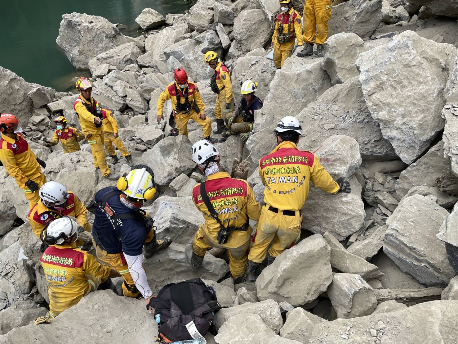 砂卡礑步道游家5人疑似罹难，已寻获两具遗体，救难人员想办法在巨石堆中开挖。图／搜救队提供
