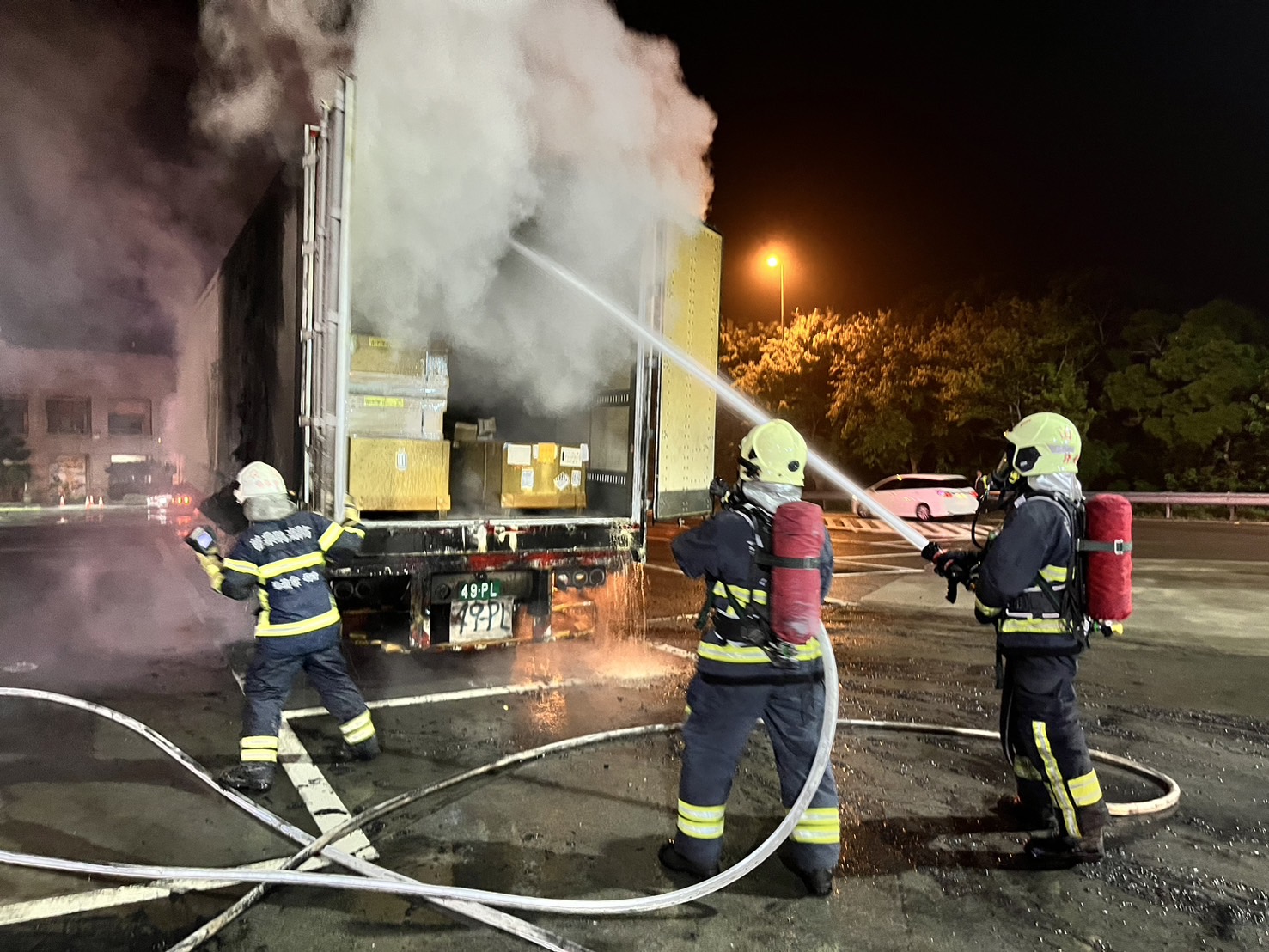 消防人车获报后赶赴现场，40呎货柜已遭火势猛烈窜烧，经确认货柜内没有禁水性物质，才开柜灭火。图／民众提供