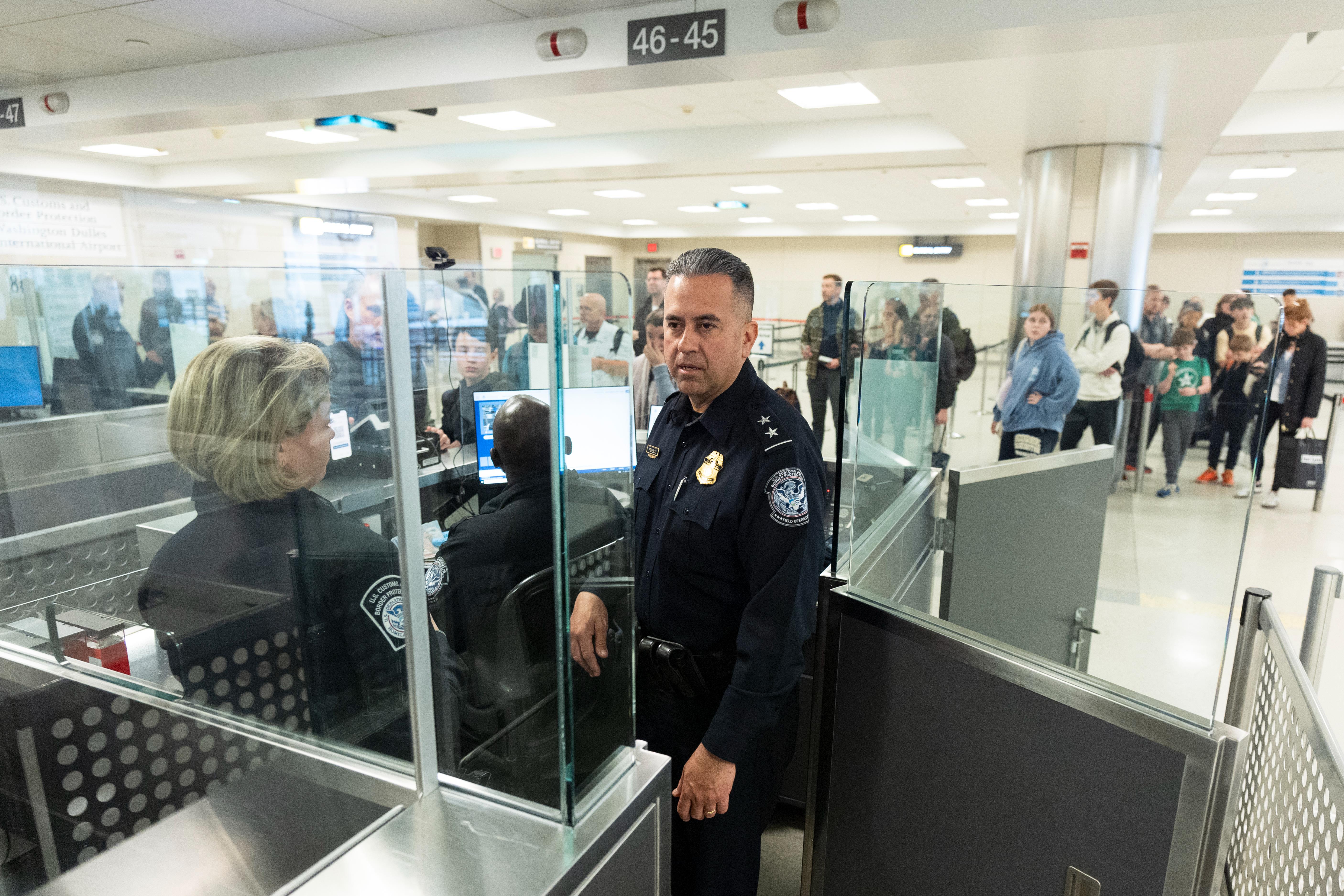图为美国海关与边境保护局官员日前在华盛顿杜勒斯国际机场入境处，观察及了解旅客入境程序。（美联社）