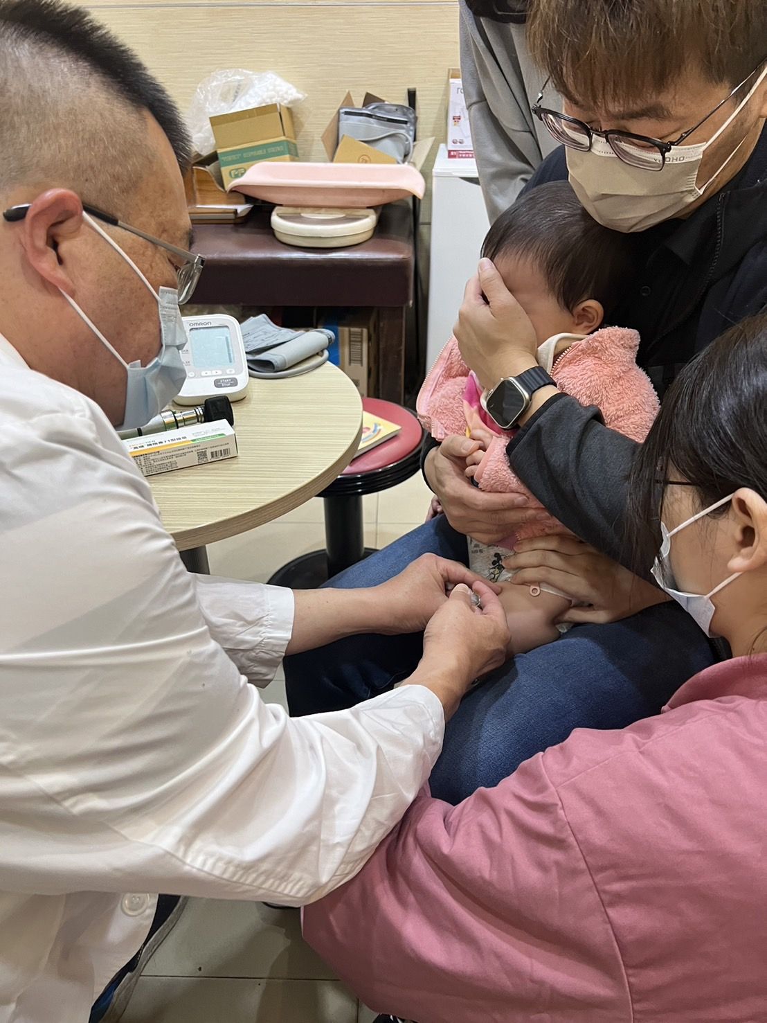 台中儿科医师施胜桓（左）说，肠病毒增温，家长带幼儿到诊所接种疫苗预防。图／施胜桓提供