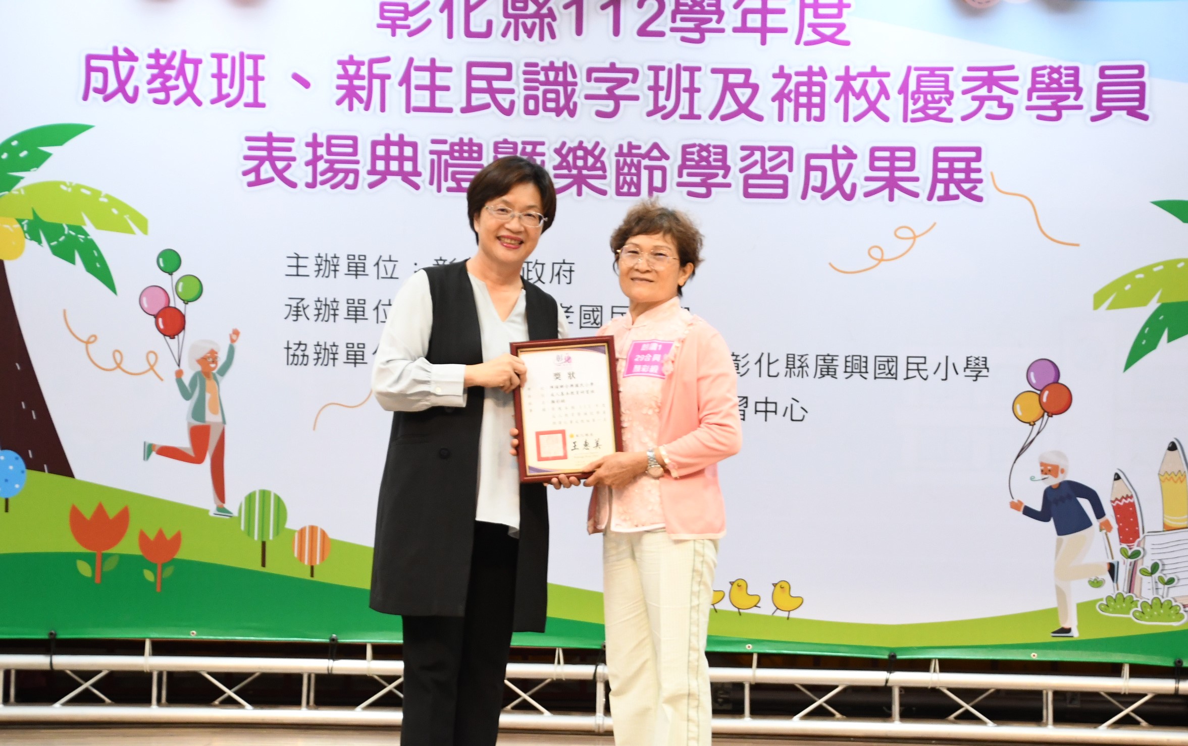 彰化县长王惠美颁奖给成人教育朗读第一名颜彩缎。图／县府提供
