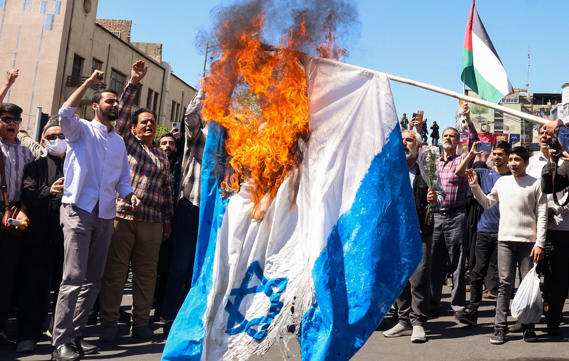 以色列表示将回应伊朗的飞弹和无人机攻击。图为伊朗民众上街焚烧以色列国旗。法新社