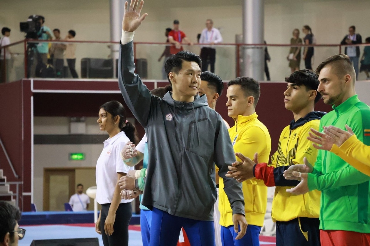 台湾男子体操好手唐嘉鸿（举手者）21日在体操世界杯杜哈站再度摘下金牌，教练也透露接下来的难度将持续提升，全力为瞄准奥运金牌而战。（翁士航提供）中央社