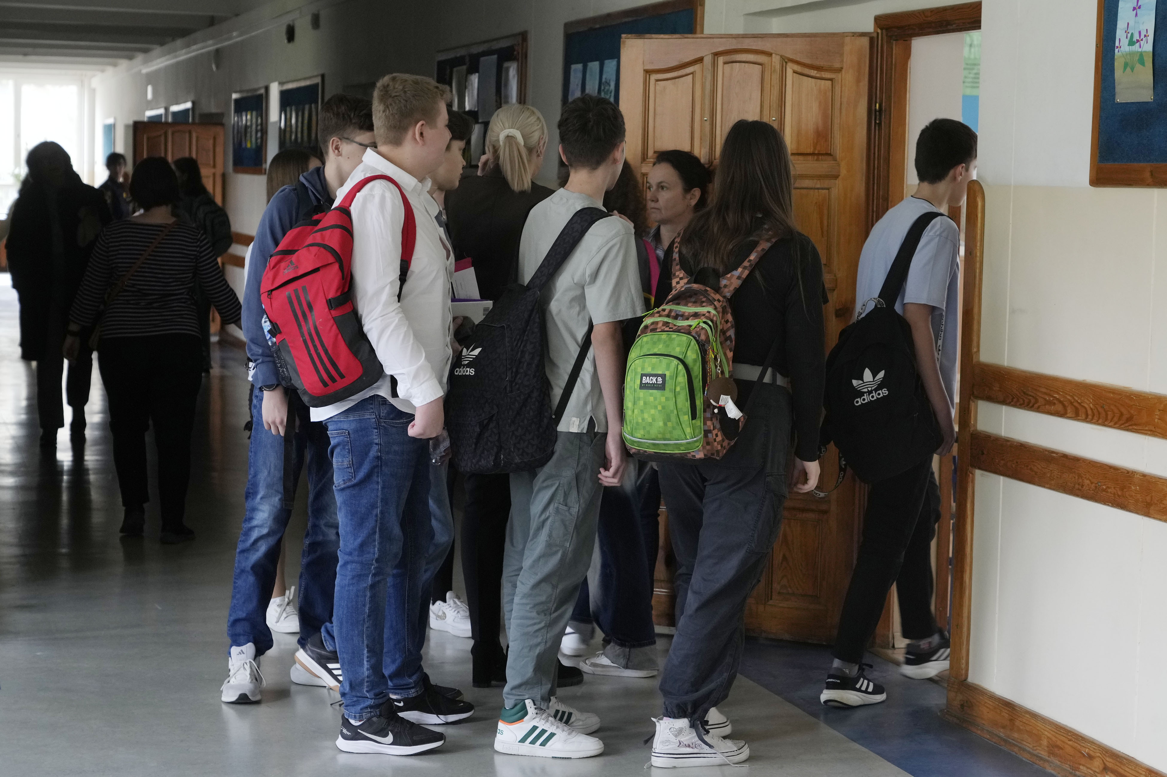 波兰首都华沙学校的学生鱼贯进入教室，开心以后不必写回家作业 。（图／美联社）