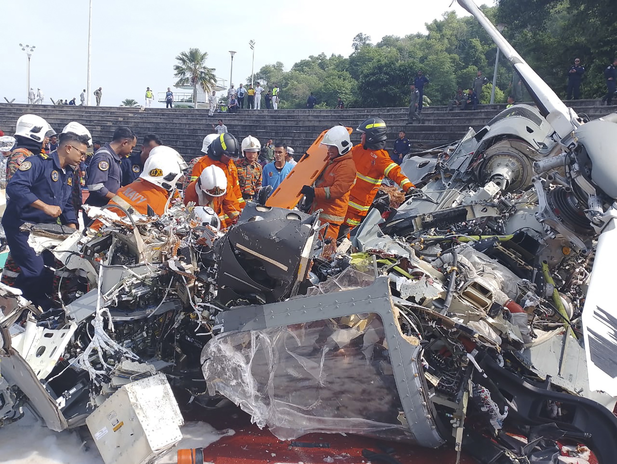 马来西亚23日两架直升机相撞坠毁酿10死，当地消防与救援部门人员到达失事现场处理。欧新社
