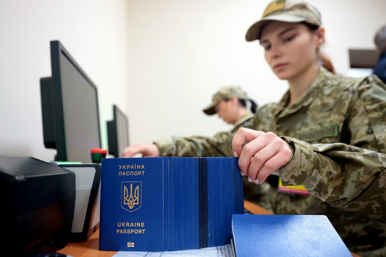 乌克兰边防人员在西部利维夫地区的铁路出境检查站整理乌克兰护照。路透