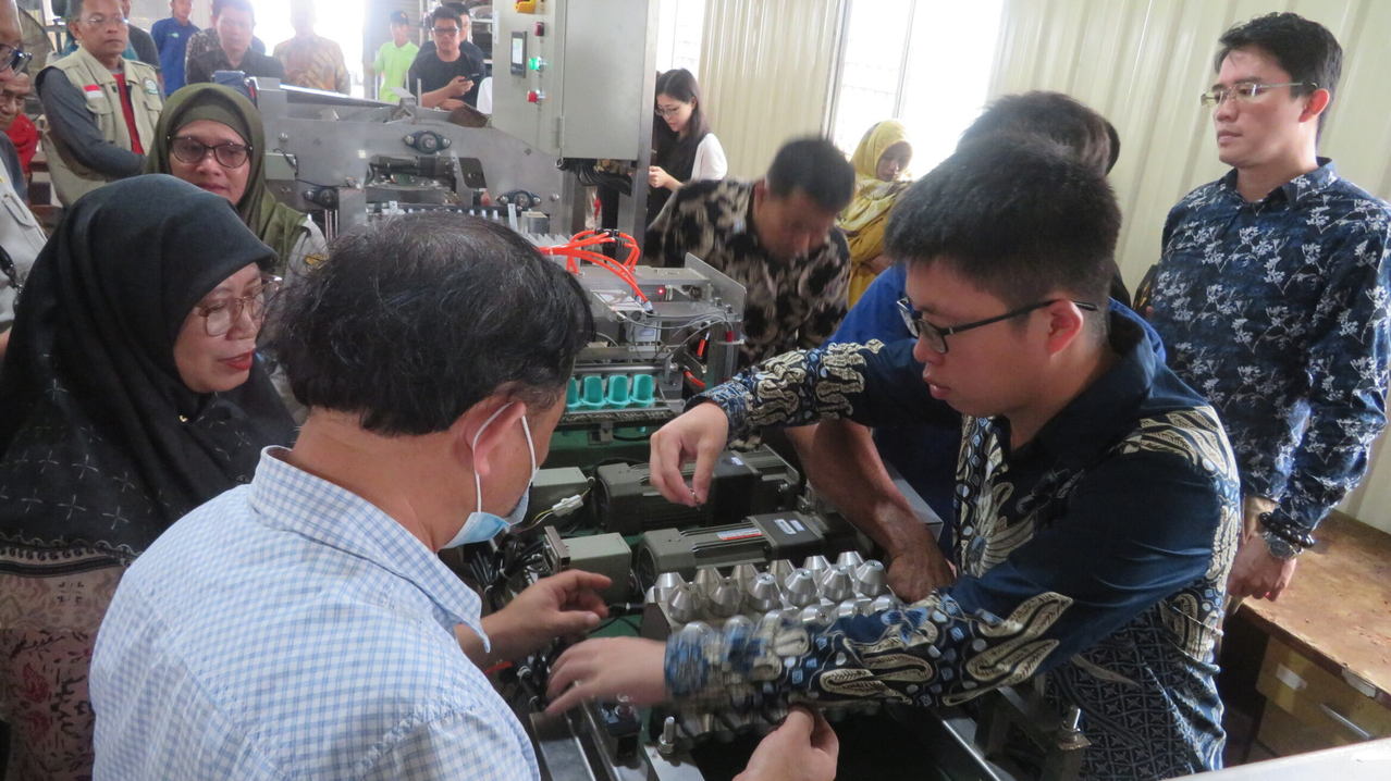 台湾技术团团员向印尼政府人员、农业学校代表及农民示范操作台制自动包装机。图／台湾驻印尼技术团提供（中央社）