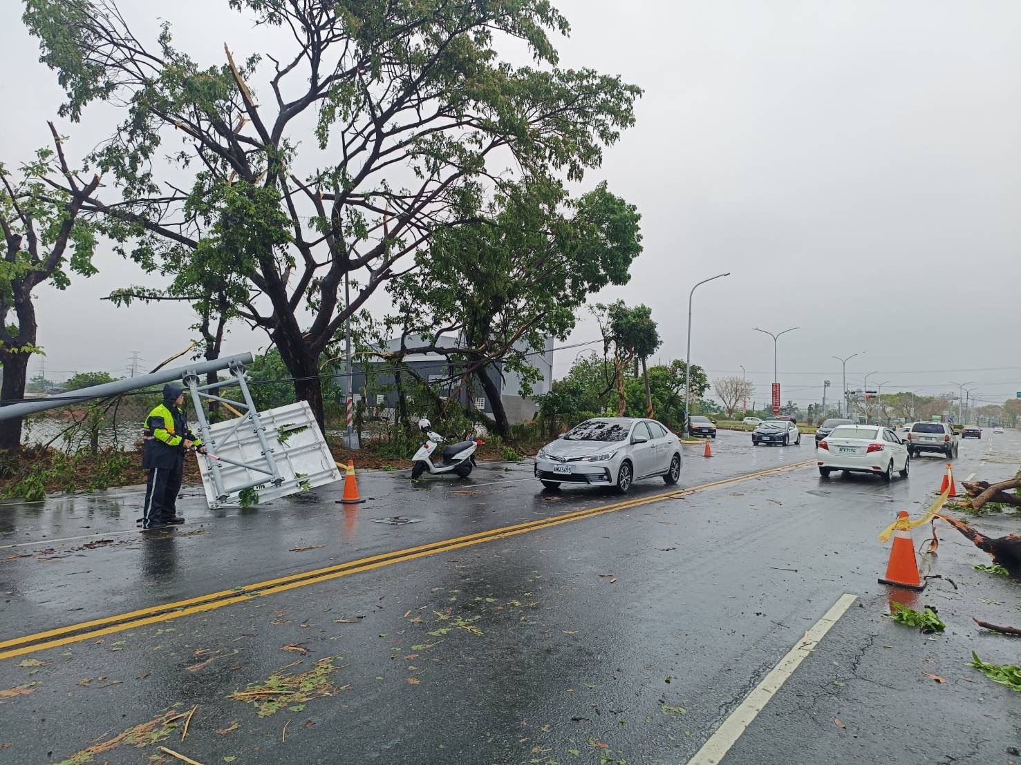 高雄市湖内区东方路今早因大雨造成路旁路树、电杆、交通号志杆倒塌，影响交通。图／湖内分局提供