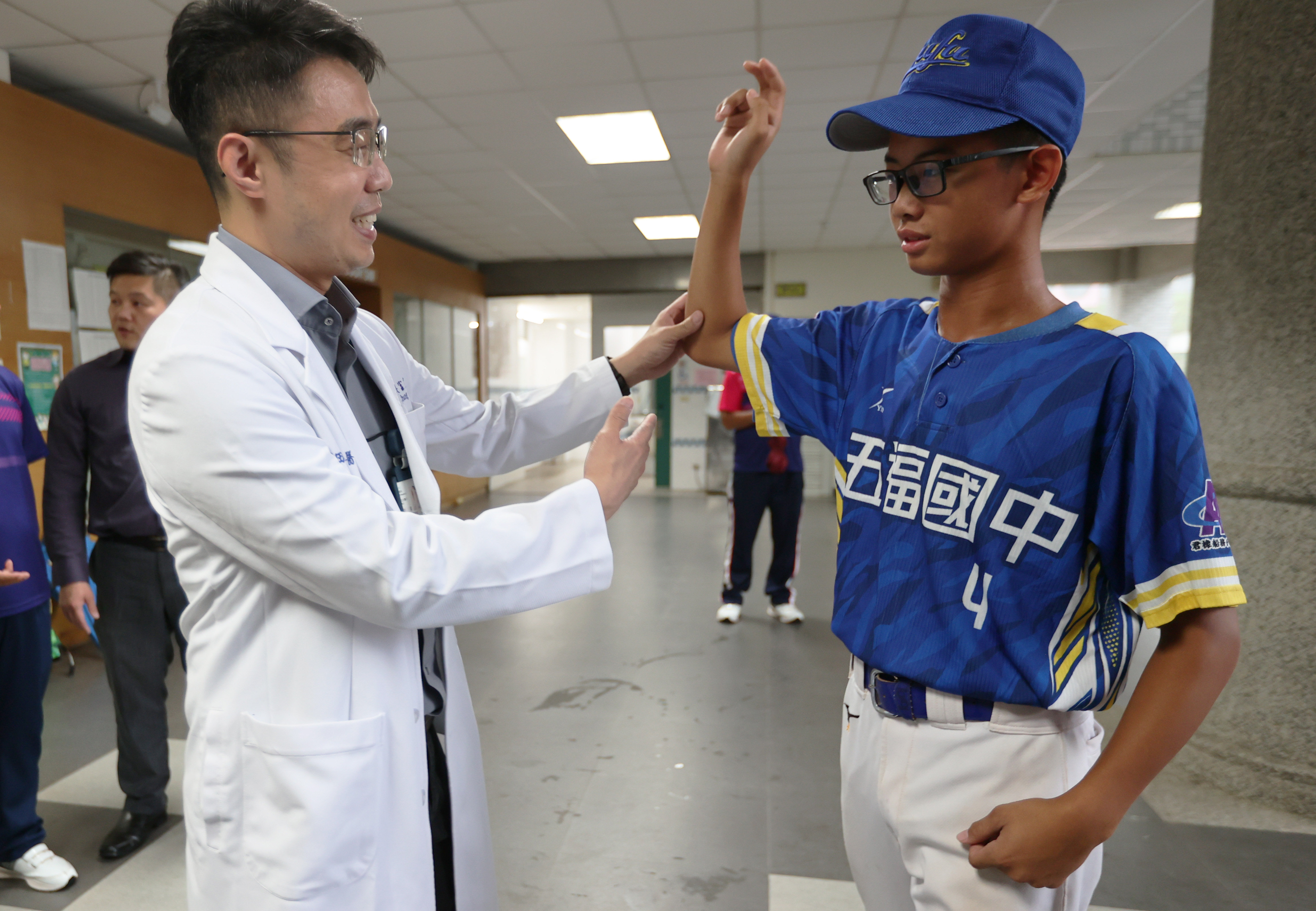 骨科医师张富淳（左）为五福国中棒球队运动员检查运动伤害。记者刘学圣／摄影