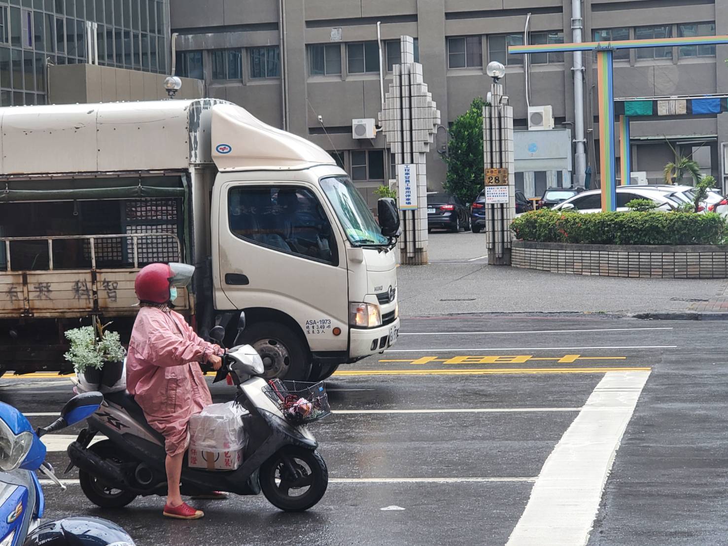 机车骑士今天中午12时许，身穿雨衣在高市三民区大昌路停等红灯。记者王勇超／摄影