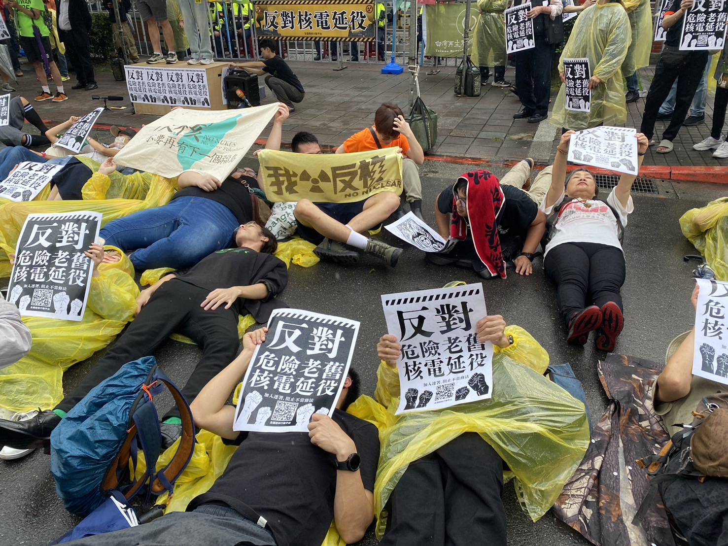 反核团体今举办「427反核占领行动10周年」活动，近百人今下午冒雨在立法院前就地躺下，模拟核灾演习。记者叶冠妤/摄影