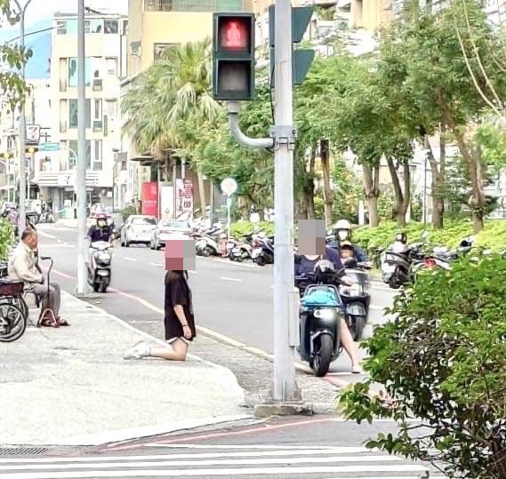 嘉义市区出现少女跪在路口画面，引来路过民众侧目。图／读者提供