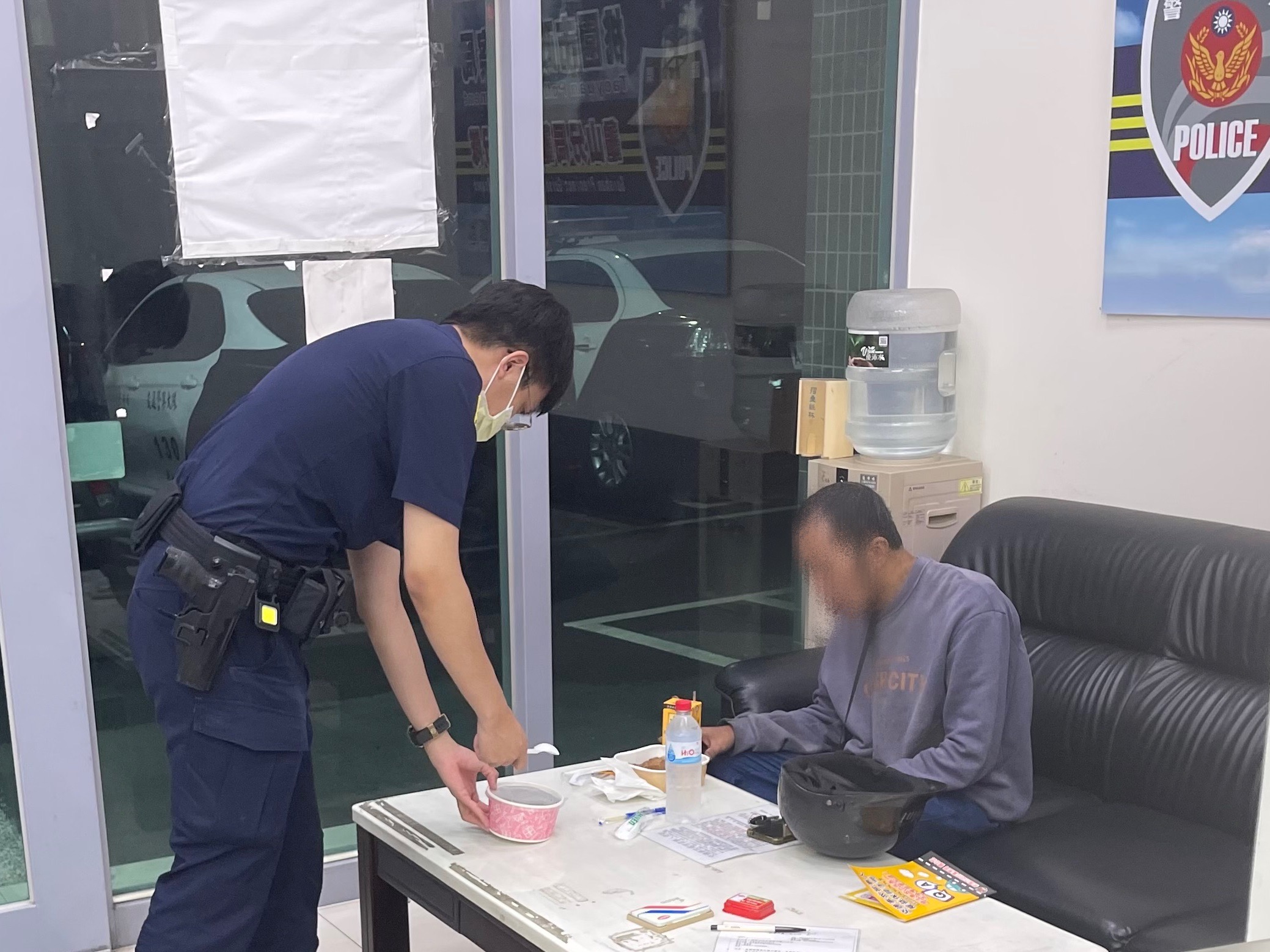 龟山警方获报41岁李姓男子因体力透支跌坐在大马路口，将他带回警局提供热食便当与饮料充饥。