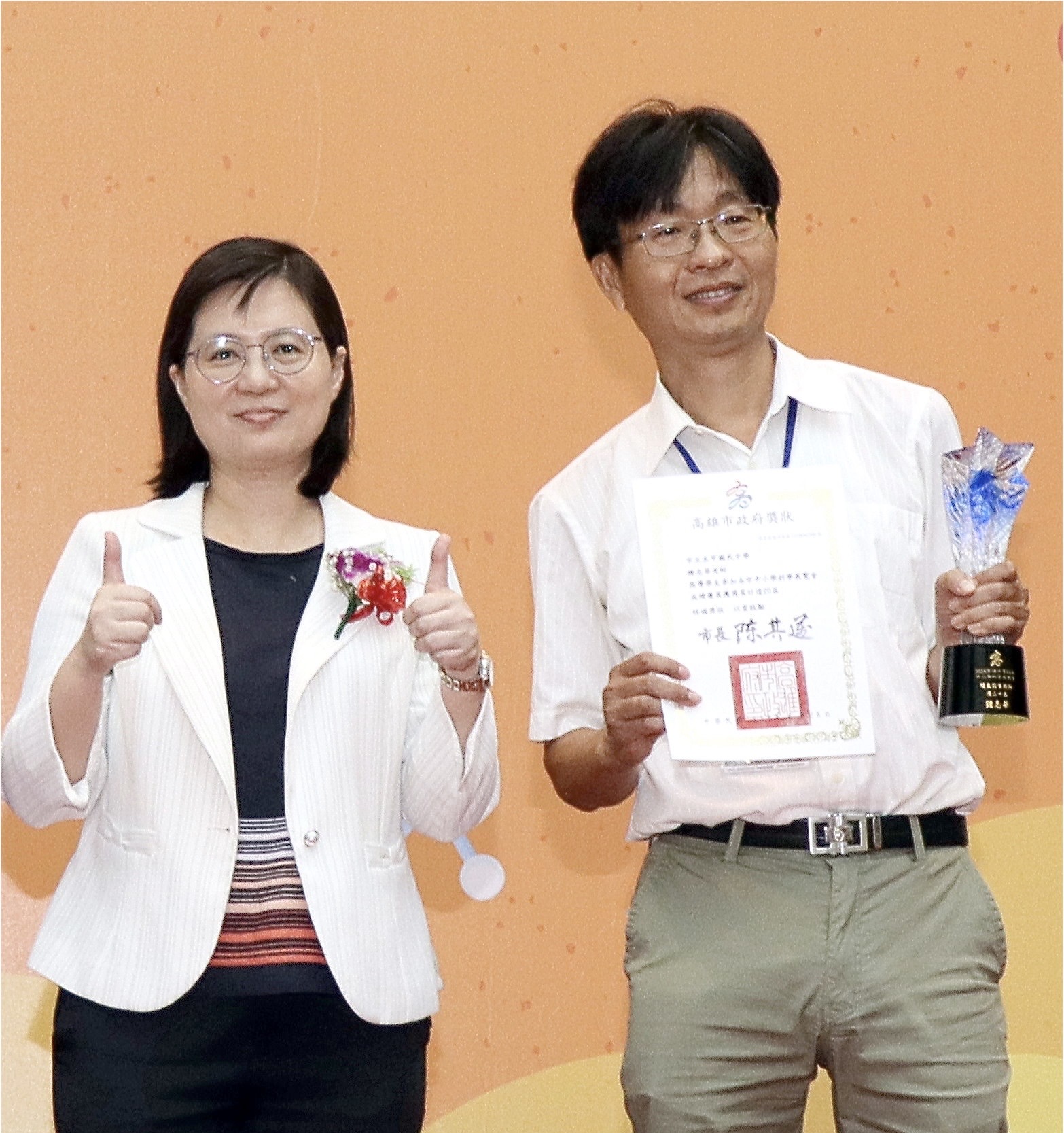 高市教育局副局长吴文静（左）颁发科展20届优良指导老师奖杯给五甲国中校长钟志华（右）。图／高市教育局提供
