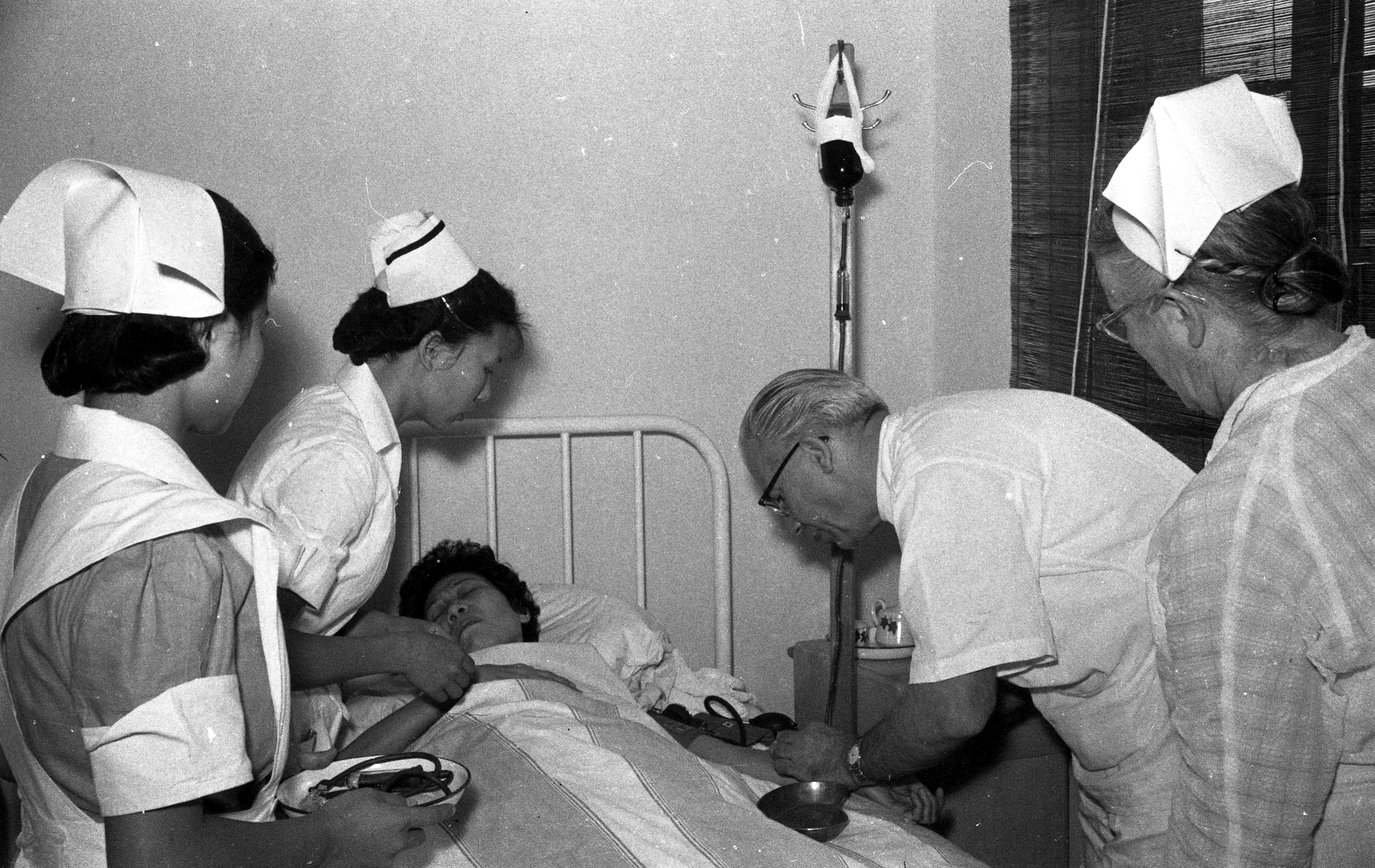 1955年5月4日，贫病女作家万绮萍到台湾疗养医院就诊，美籍主任医师卜凯士（右二）诊断，她久病贫血，需要及时大量输血才能保命。图／联合报系资料照片