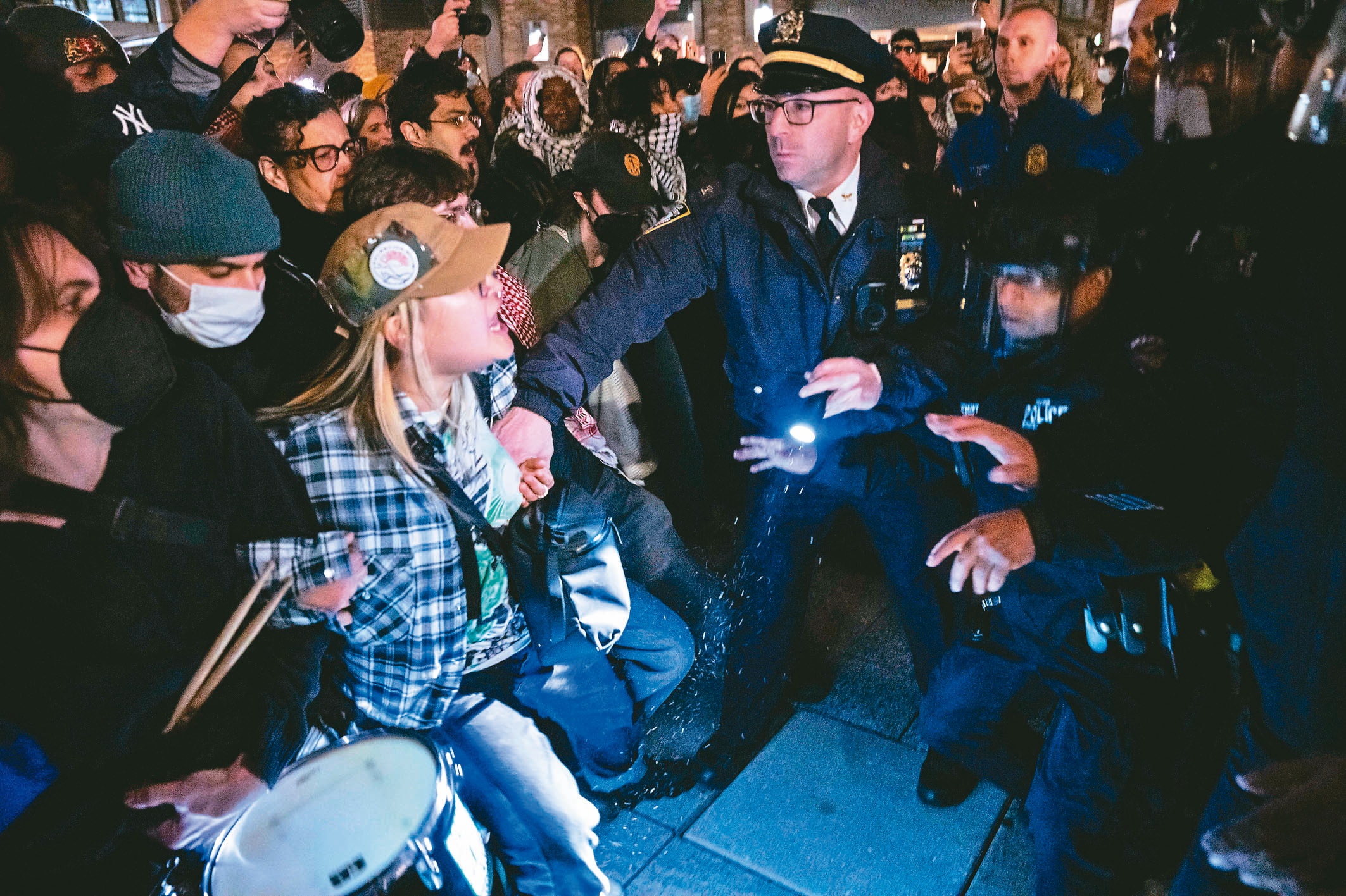 警方4月22日晚间进入曼哈顿格林威治村邻近地区的纽约大学外，逮捕呼吁结束加萨战争的抗议者。（纽约时报）