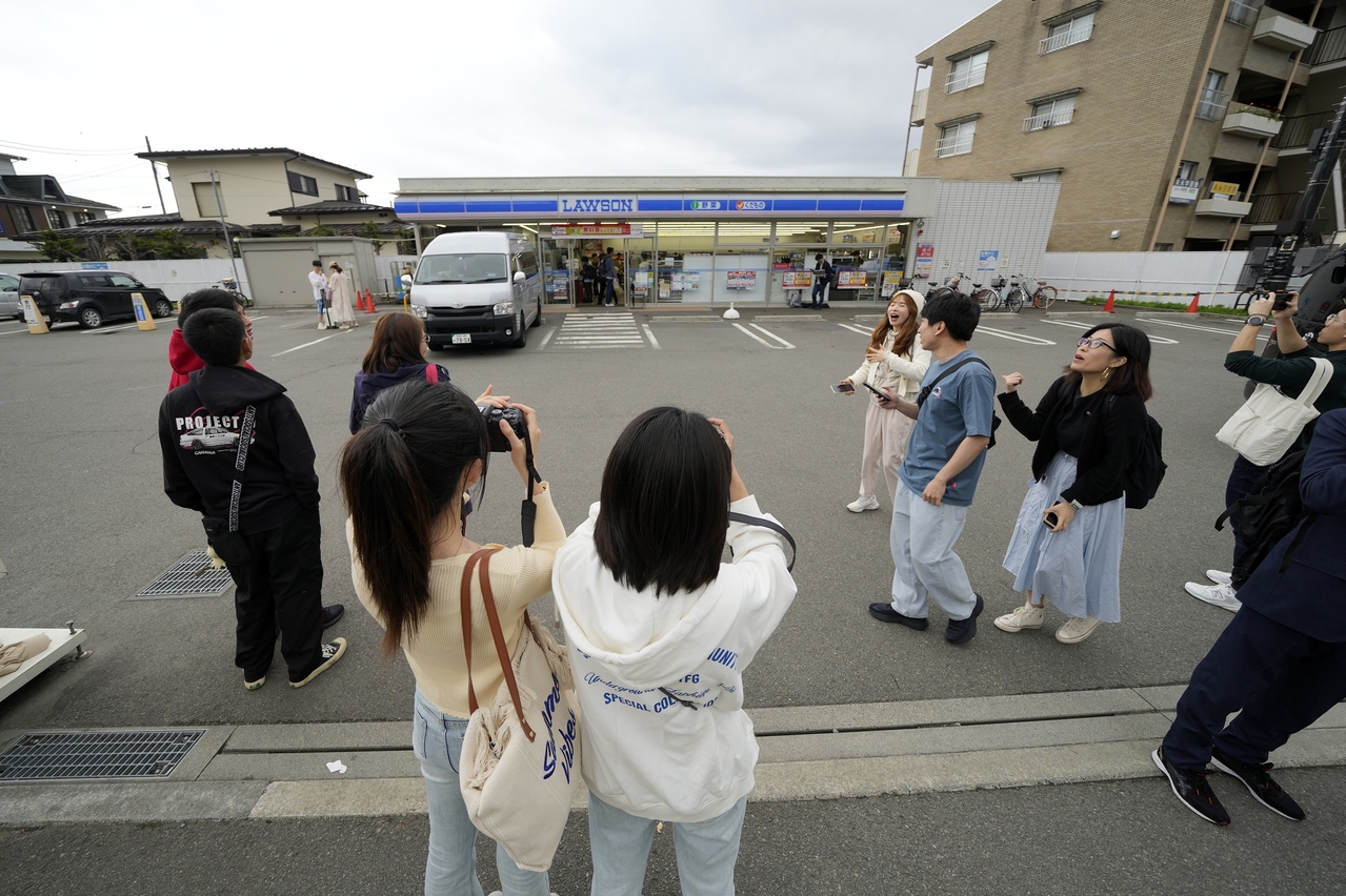 日本在罗森便利商店外架起黑色布幕，阻挡过量游客聚集拍摄富士山，没想到外国观光客很快又找到另一间同样能拍摄富士山的罗森便利商店，附近因人潮也开始出现妨碍车辆通行的问题。