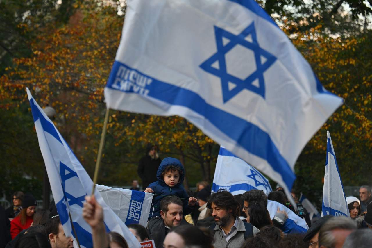 纳粹大屠杀的权威专家达扬回应尔登行为表示，「今时今日，我们胸前应该配戴蓝白国旗，而非黄星。」图为民众在11月1日纽约市的纪念活动上挥舞以色列国旗。法新社