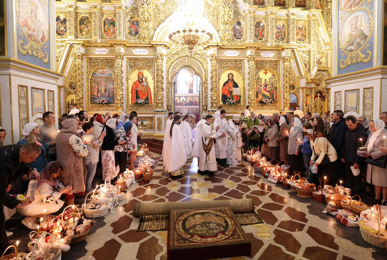 5月5日，基辅佩乔尔斯克修道院圣母升天大教堂举行的复活节仪式上，东正教信徒站在传统复活节美食篮旁，接受乌克兰牧师的祝福。法新社