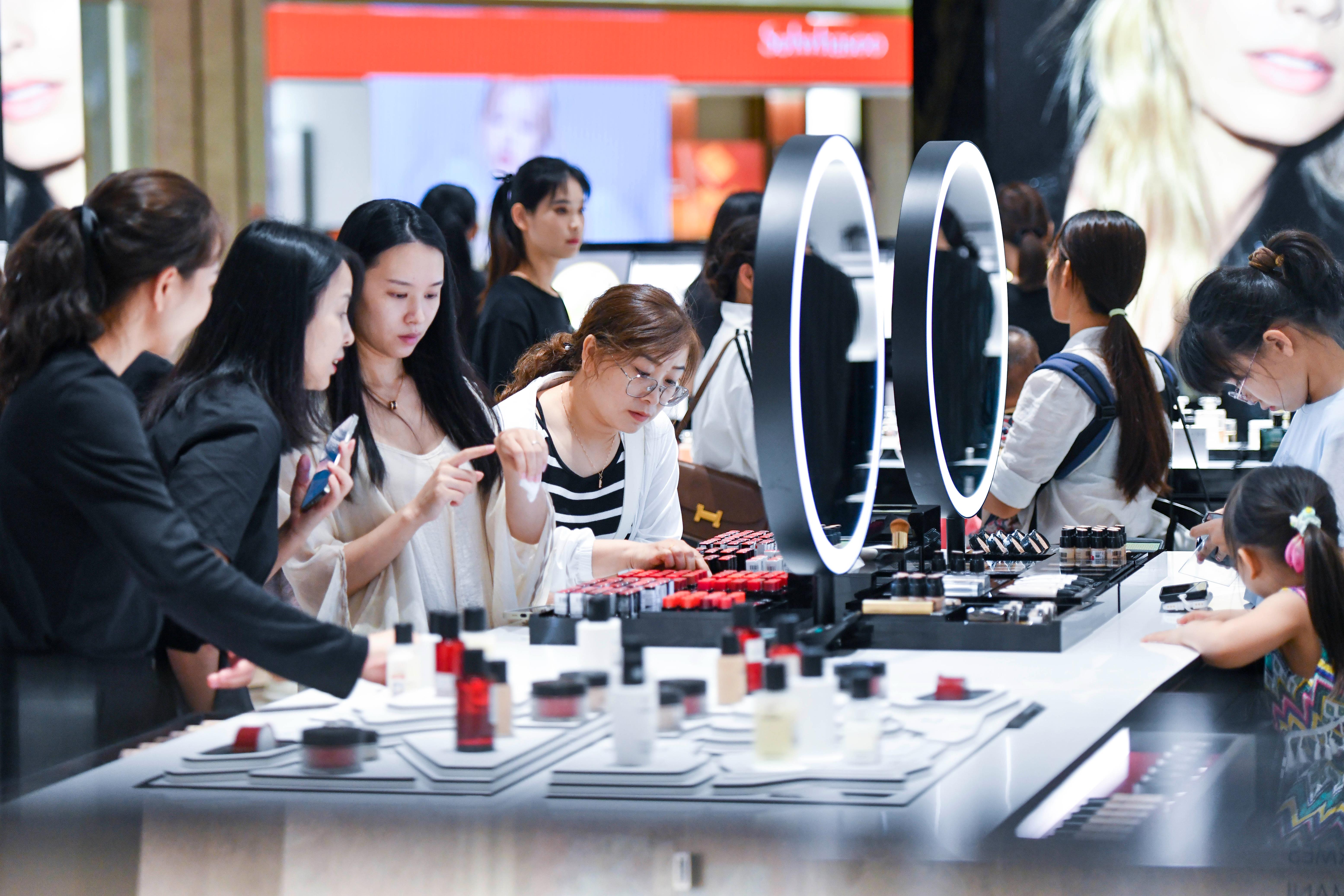 大陆4月财新服务业PMI微降至52.5，图为海南海口国际免税城内消费者正在选购化妆品。（中新社）