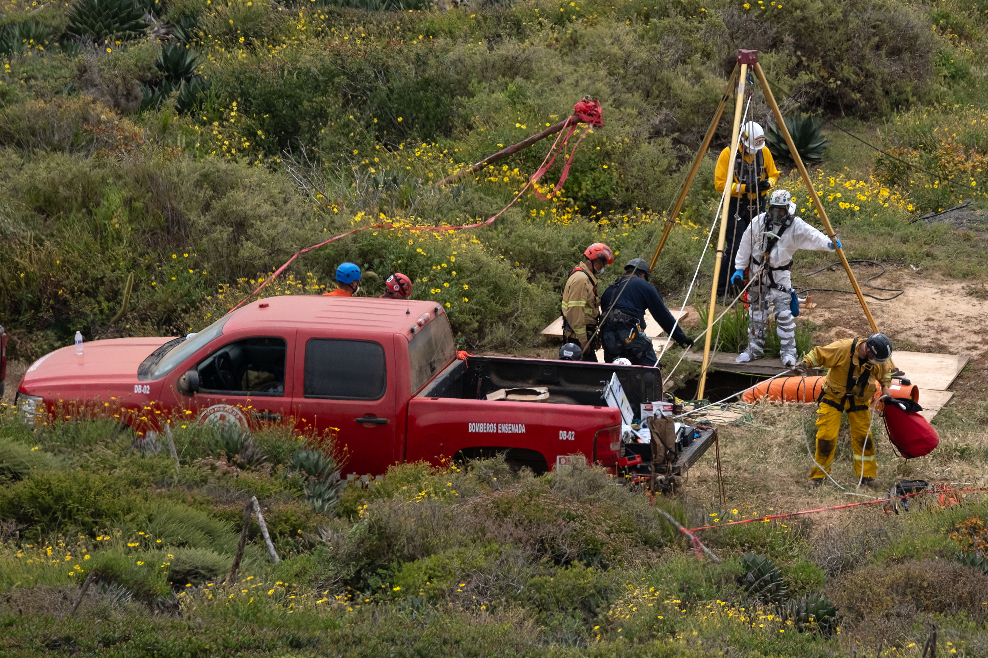 墨西哥下加州日前在偏僻竖井发现3具男尸，5日经家属指认，证实是来自澳洲和美国的3名冲浪客。图为警方将遗体从竖井中吊出。法新社