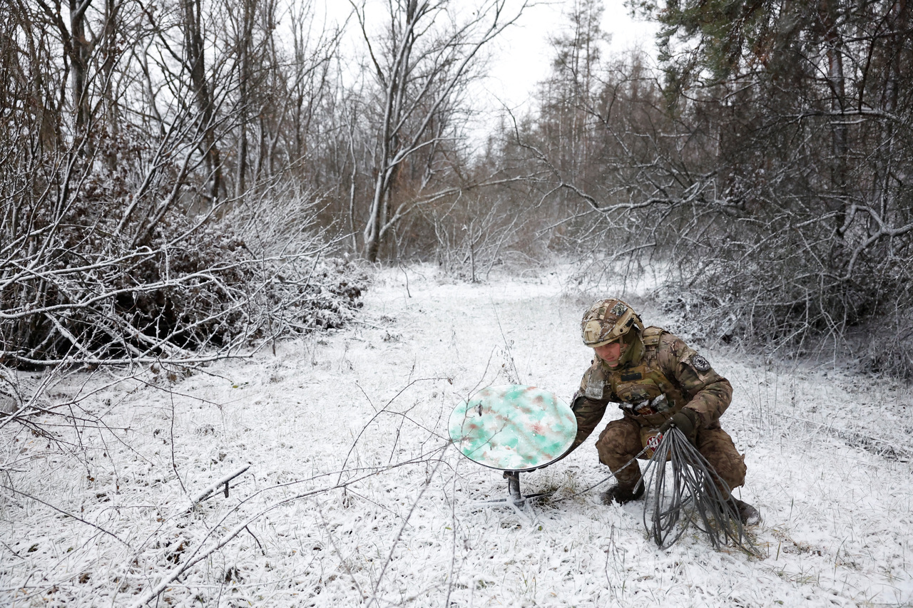 图为乌克兰士兵在雪地里调整星链接收器。路透社