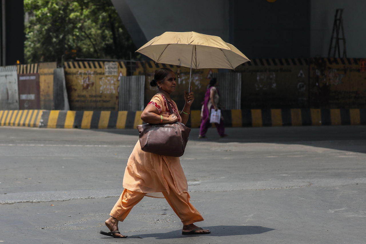 图为印度一名在艳阳下撑伞的行人。示意图／欧新社资料照