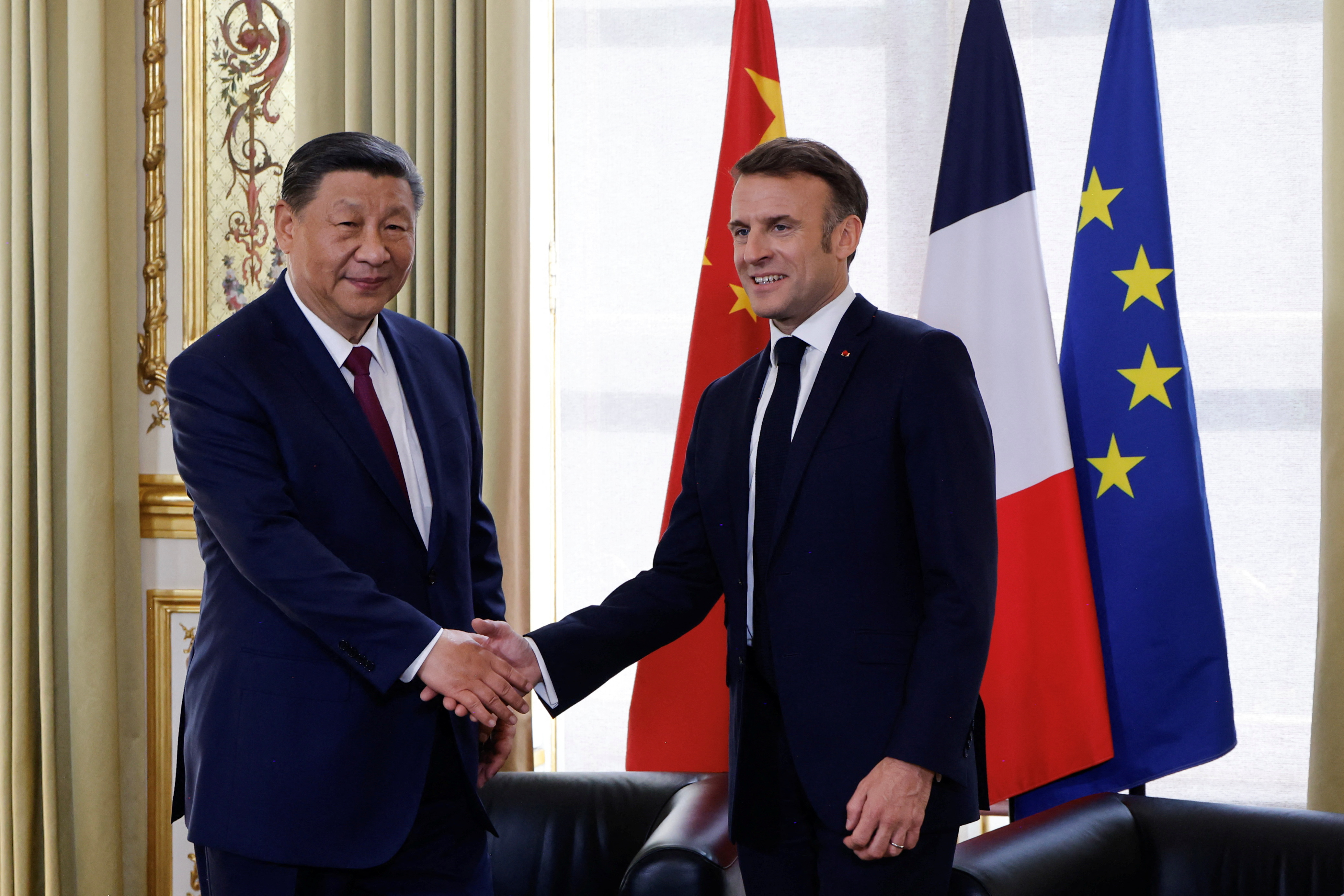 中国大陆国家主席习近平（左）与法国总统马克宏（右）在巴黎爱丽舍总统府举行双边会面之前握手。路透