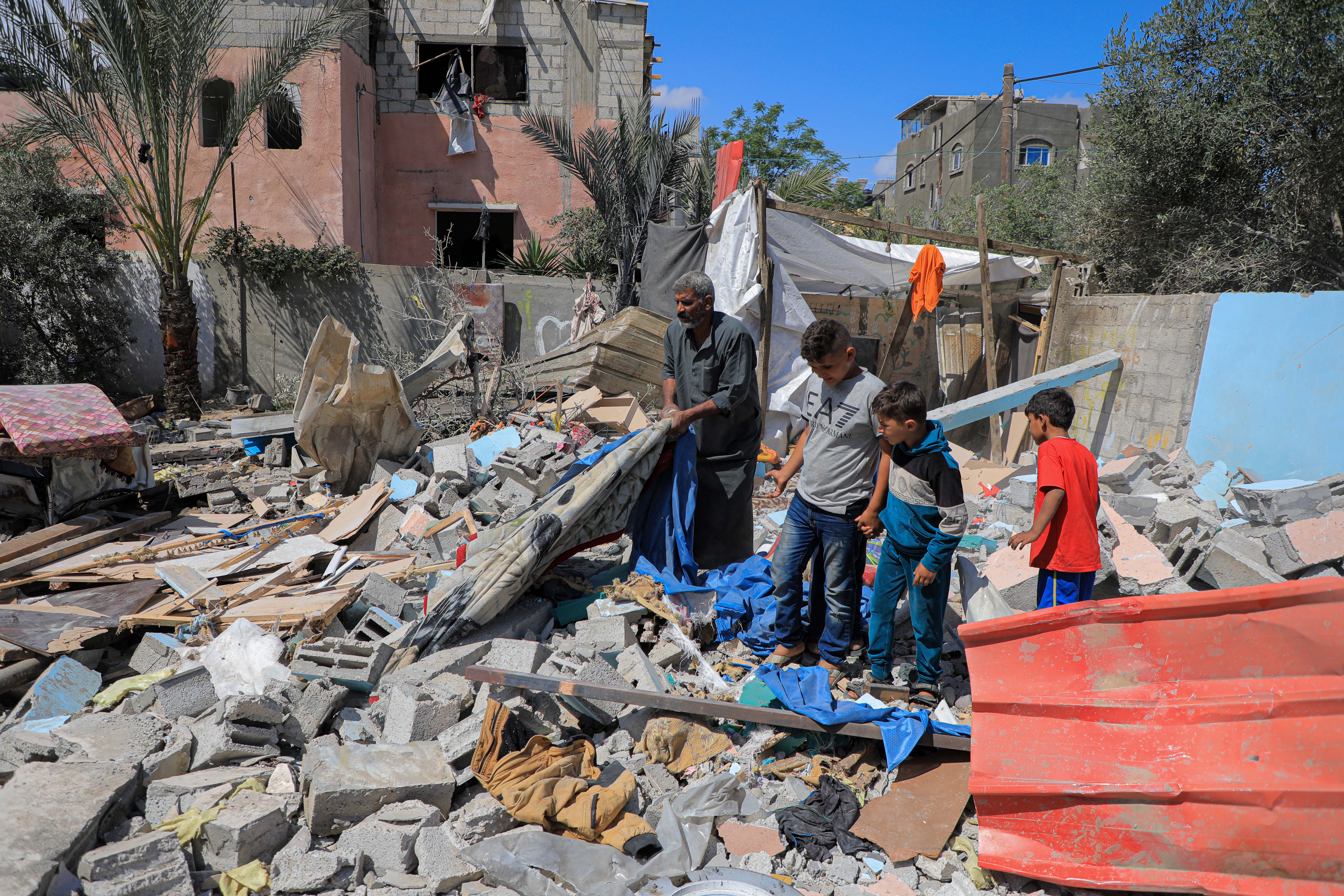 图为加萨地区居民查看轰炸后的废墟。（新华社）