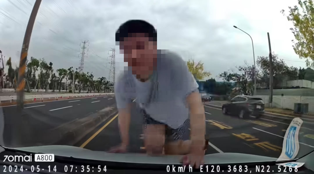 男子今天在高雄市小港区爬上行驶快车道的轿车。图／撷取自脸书爆废公社