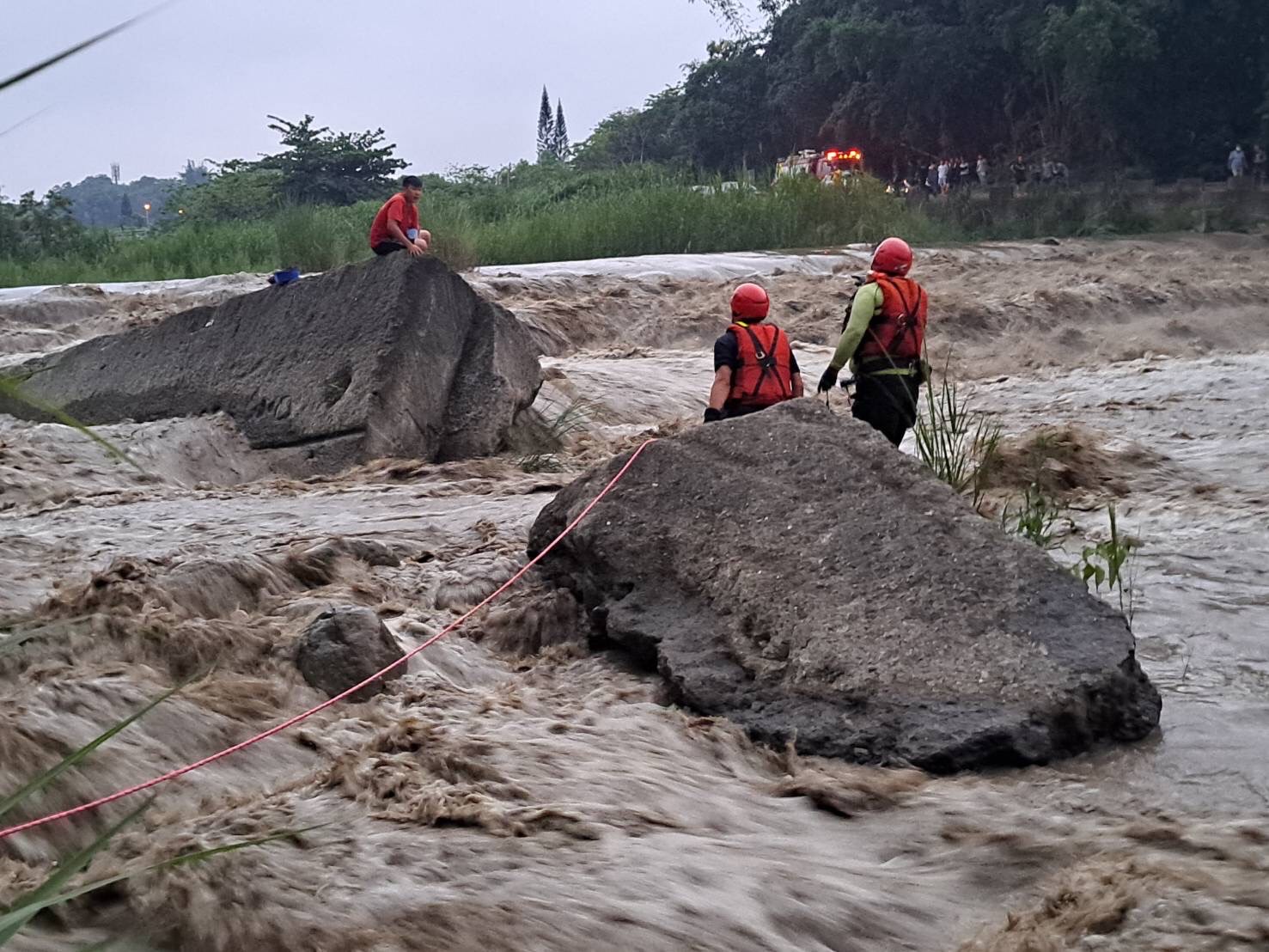 嘉义县山区溪水暴涨，竹崎亲水公园今天下午传出钓客受困，消防人员将他安全救出。影／读者提供