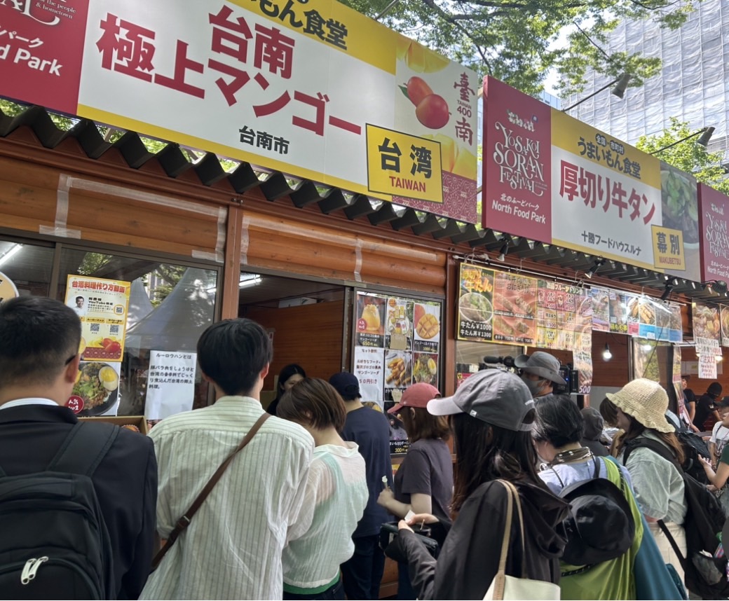 台南爱文芒果颇受日本消费者青睐，在日本北海道的索朗祭会场，「台南物产」专区不时有民众大排长龙，就为品尝一口芒果的美味。图／台南市政府提供