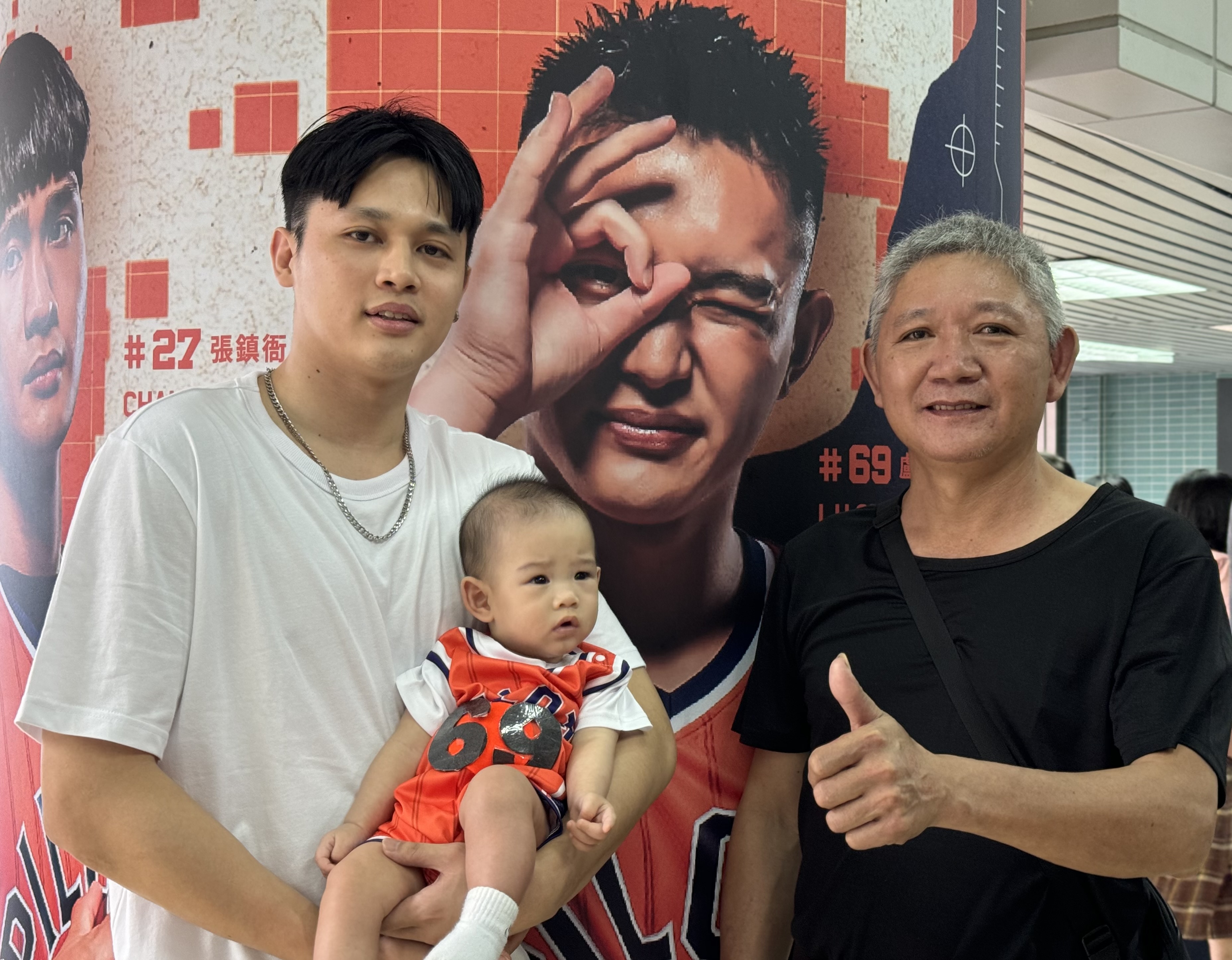 卢捷闵（左）抱著7个月大的儿子和爸爸杨左勤一起进场，为弟弟卢峻翔加油。记者曾思儒／摄影
