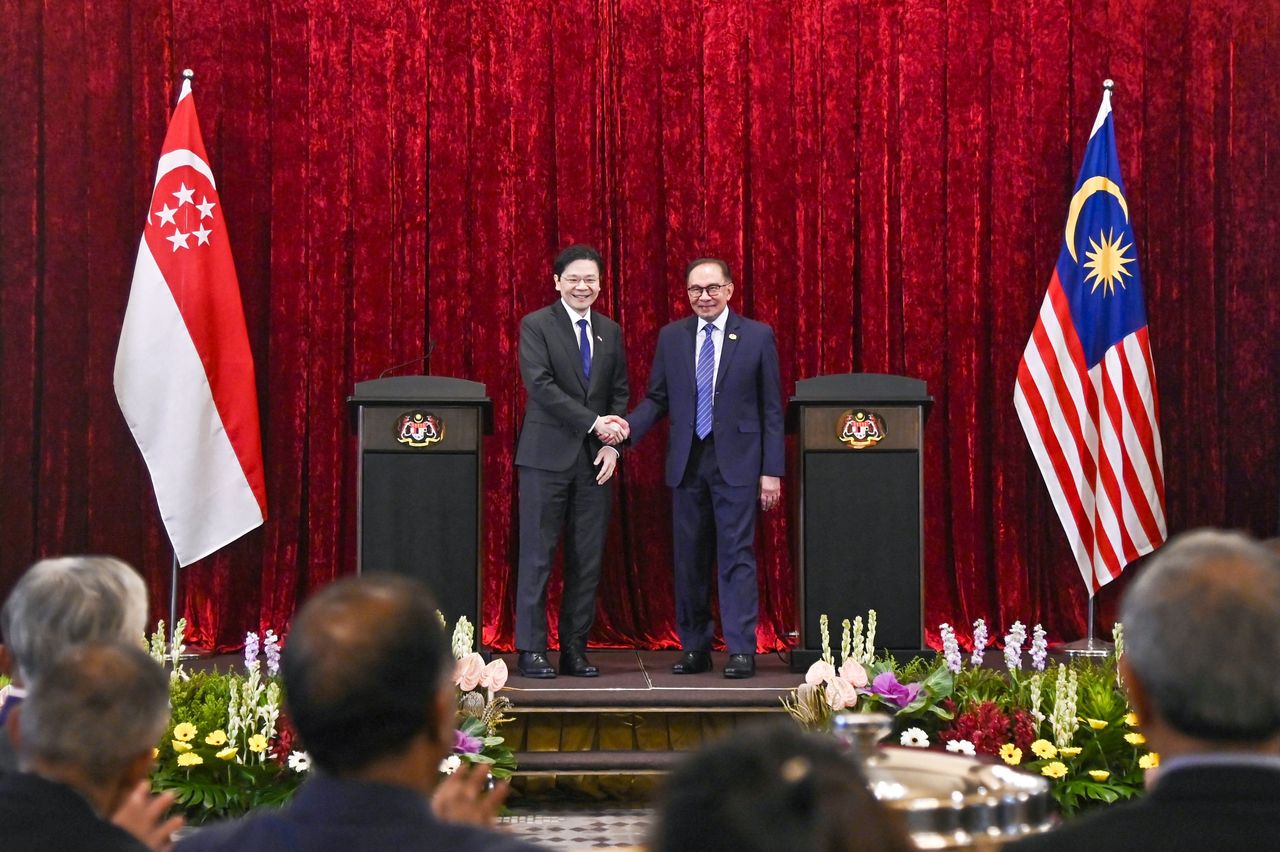 马来西亚首相安华（右）与首度来访的新加坡总理黄循财（左）会谈。