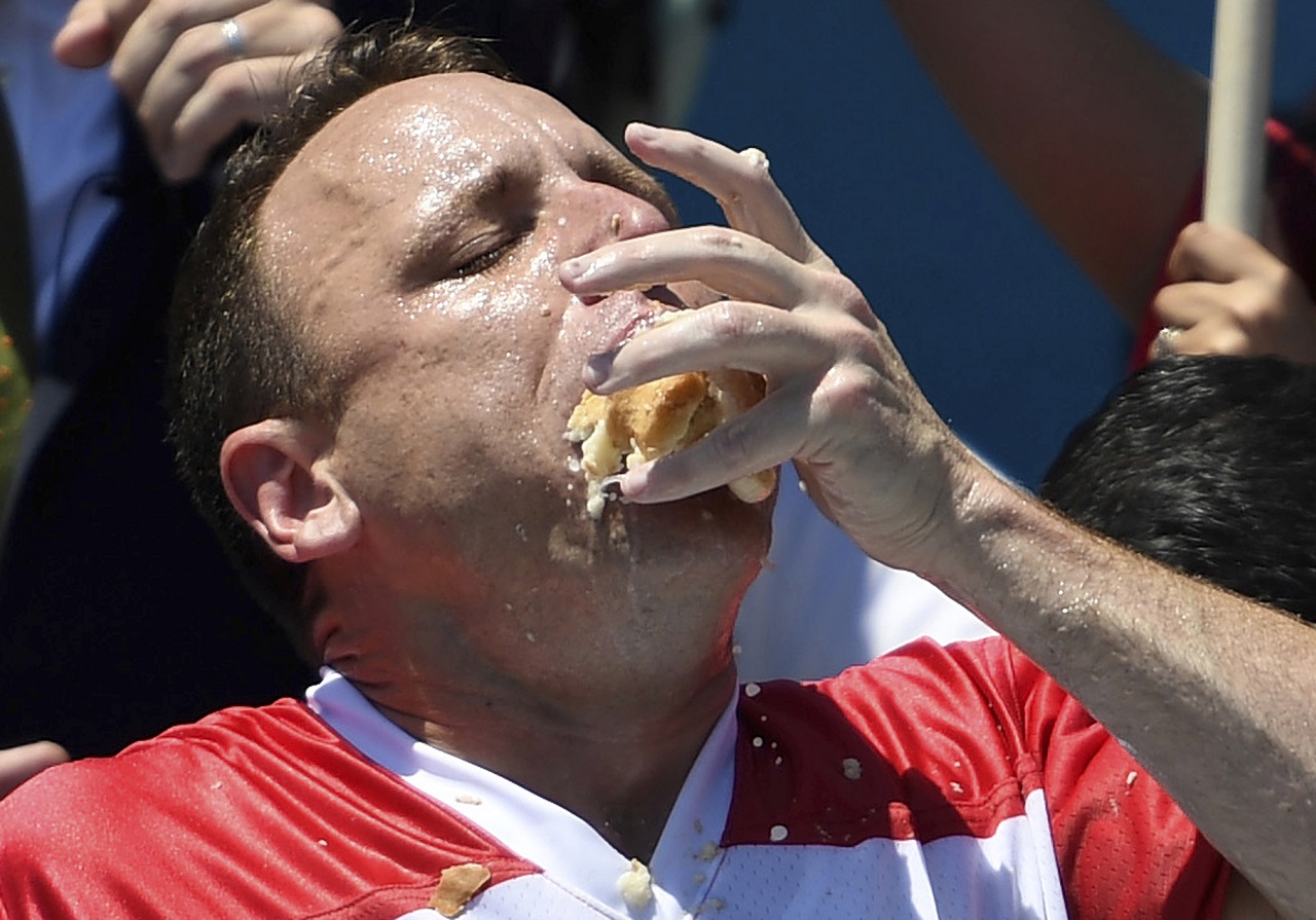 美国大胃王切斯纳参加2019年的Nathan's Famous独立日吃热狗大赛男子比赛时，嘴巴塞满热狗面包。美联社