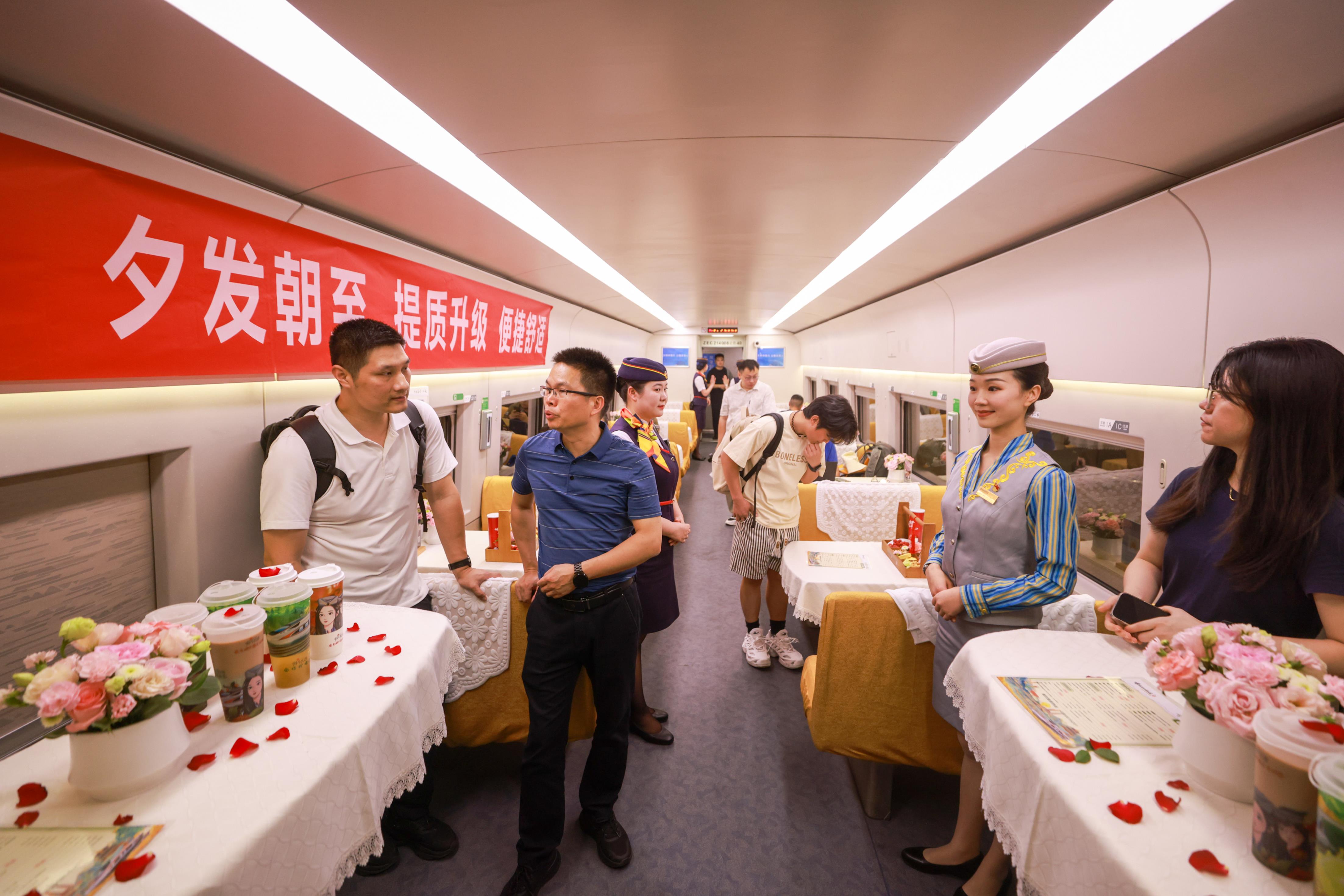 6月15日晚，开往香港西九龙站的D909次列车即将从北京西站发车，一些旅客在餐车内等待用餐。（中新社）
