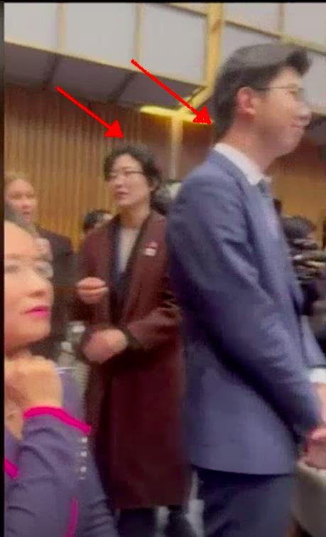 大陆国务院总理李强与澳洲总理艾班尼斯会面现场，中方人员（红箭头所指）试图遮挡坐在记者席上澳籍华裔记者成蕾（左一）。（图／截自澳洲广播公司视频）